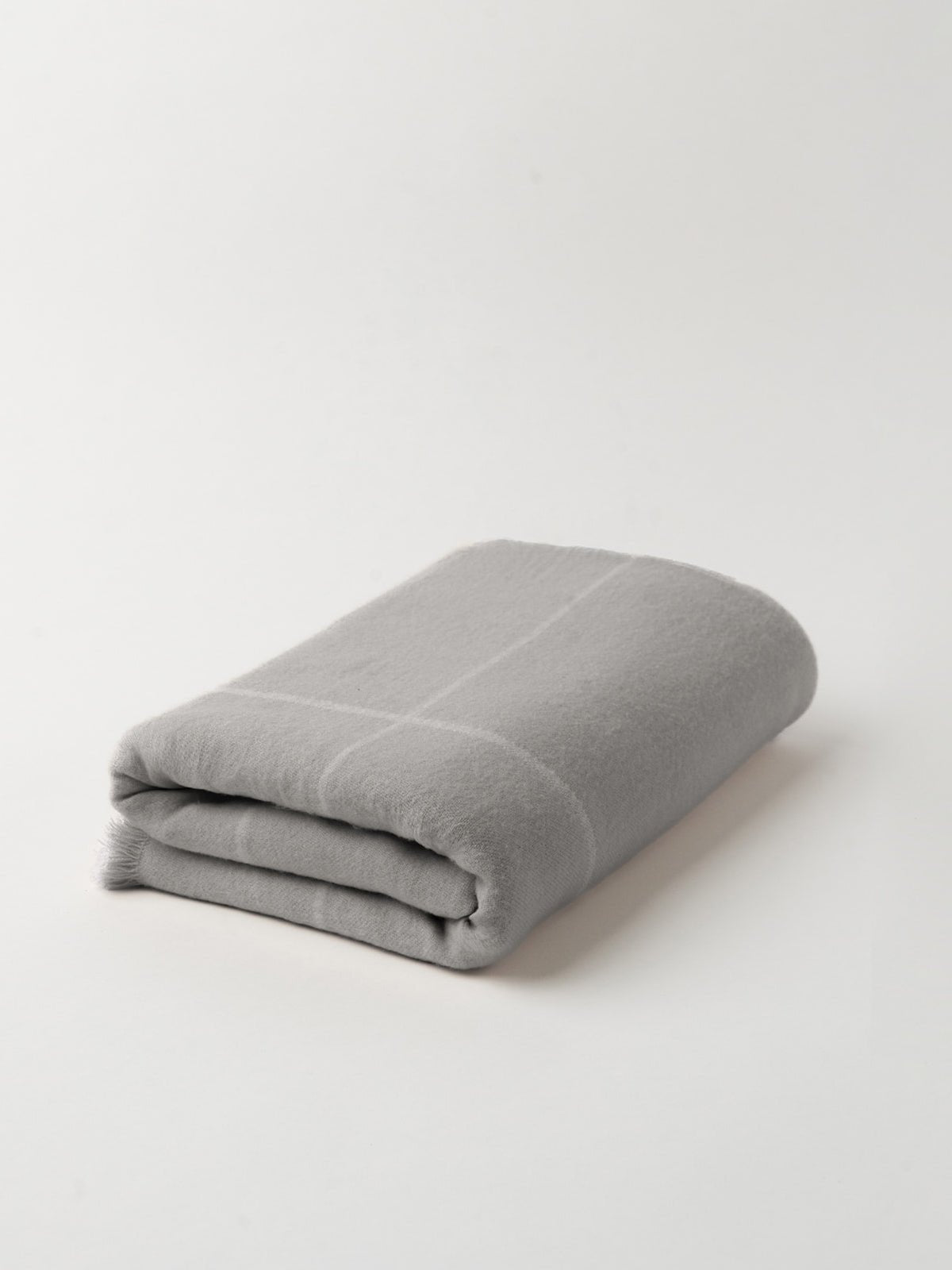Grey windowpane blanket folded with white background 