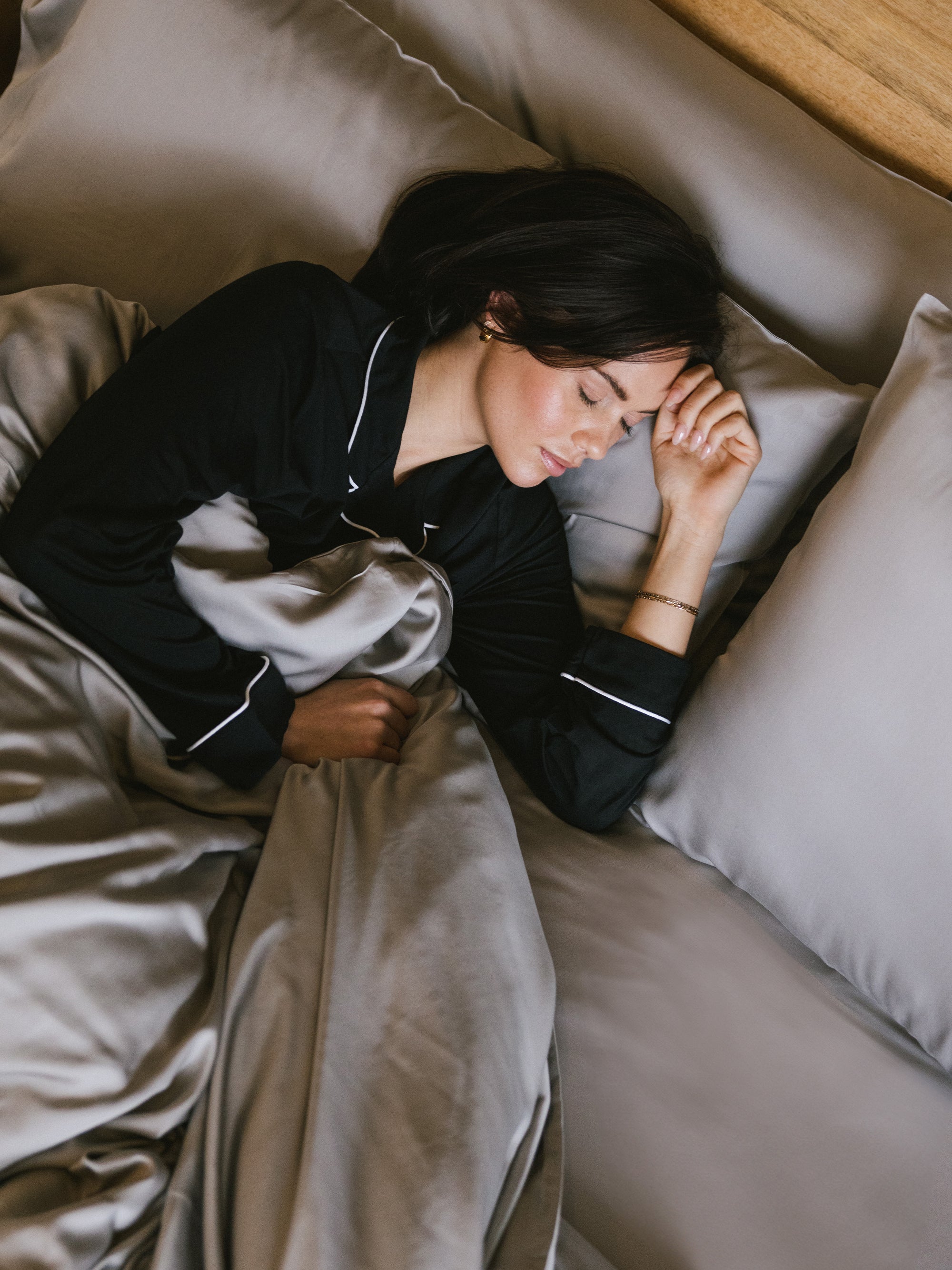 Woman sleeping in bed with dove grey bedding standard/king/body 