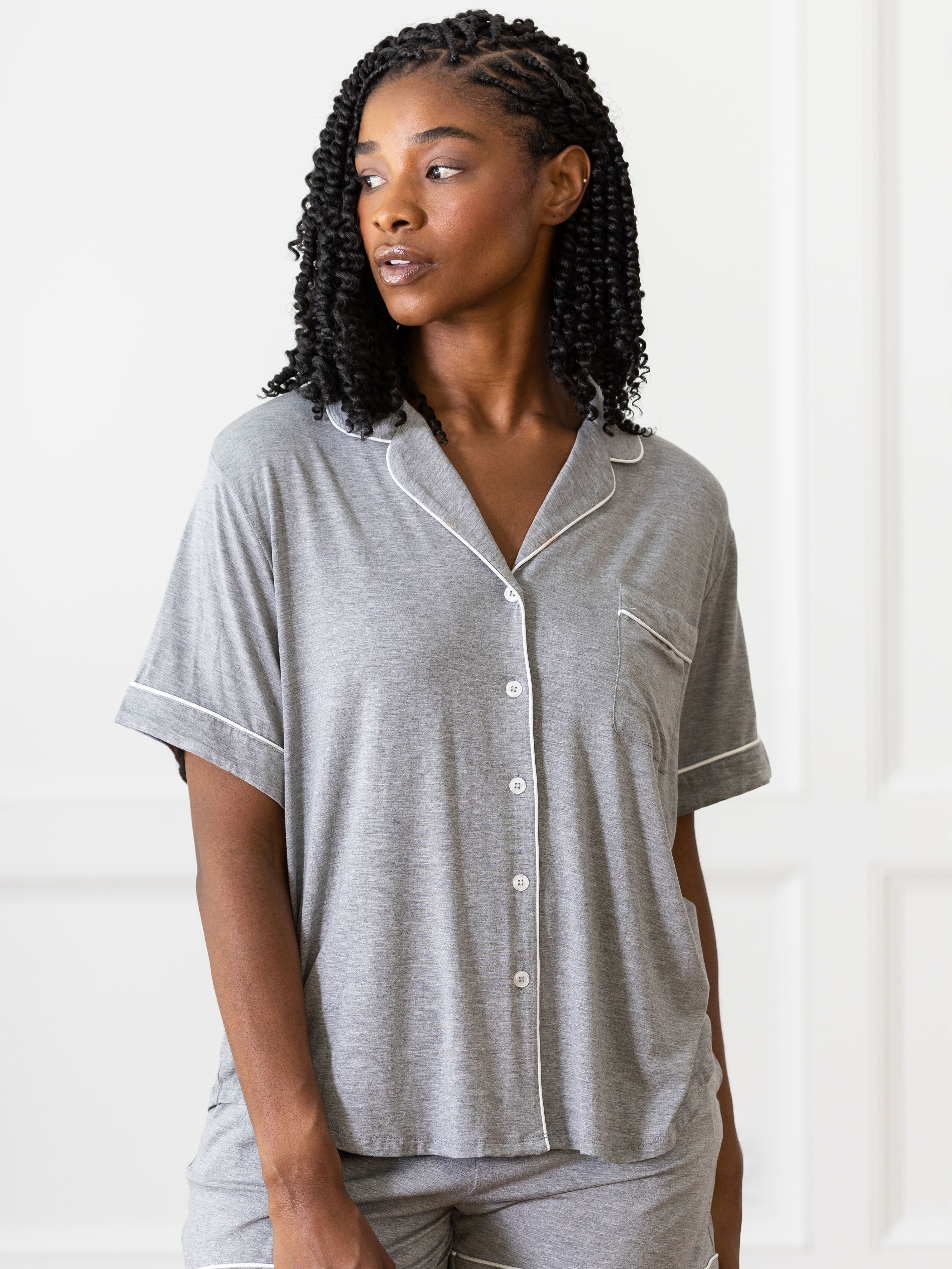 Grey Short Sleeve Pajama Set modeled by a woman. The photo was taken in a light setting, showing off the colors and lines of the pajamas. 
