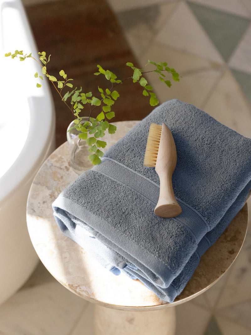 Harbor mist hand towels on small table with brush