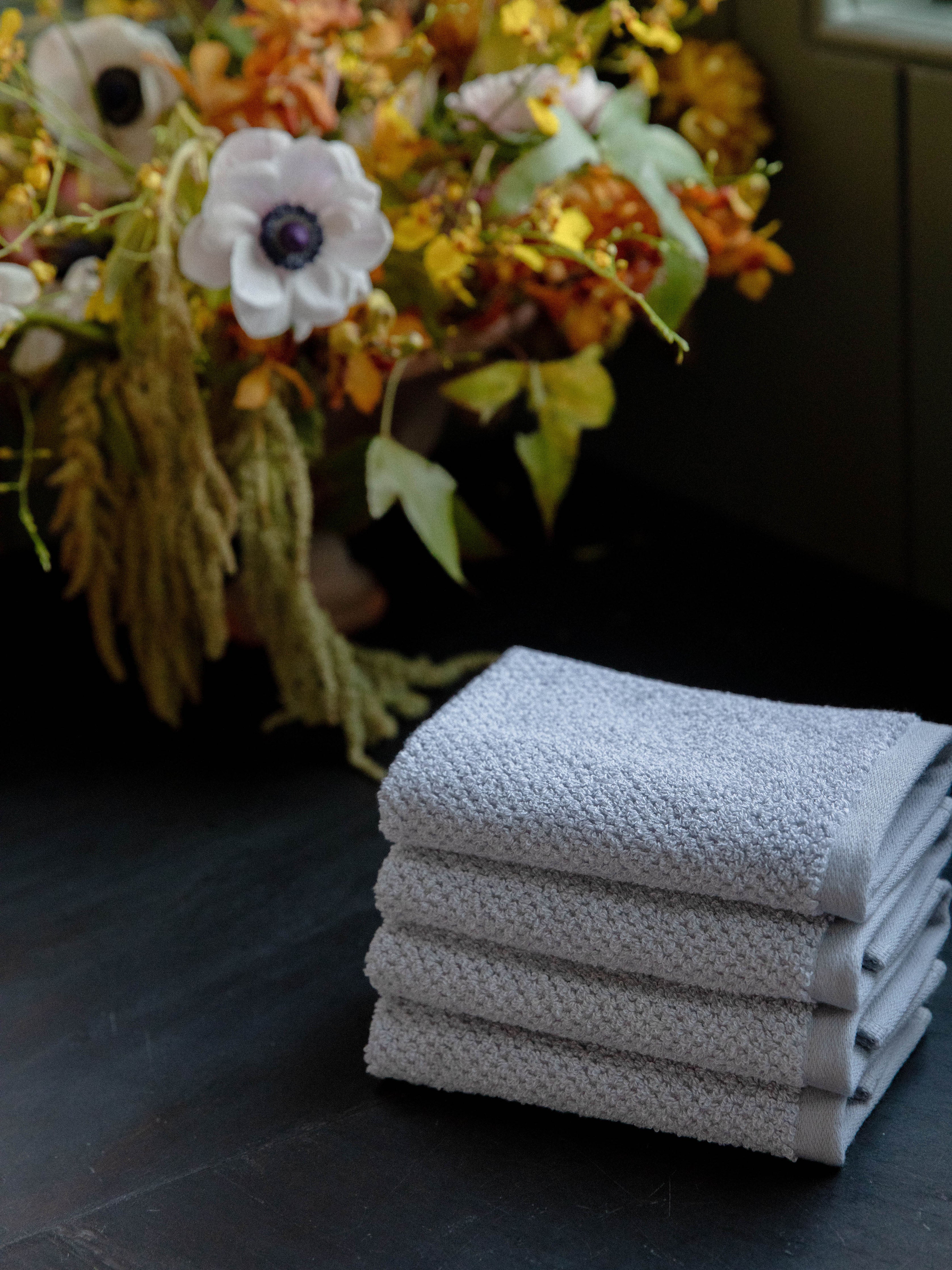 Nantucket Wash Cloths in the color Heathered Harbor Mist. Photo of Nantucket Wash Cloths taken with the Wash Cloths resting on a countertop in a bathroom. |Color: Heathered Harbor Mist