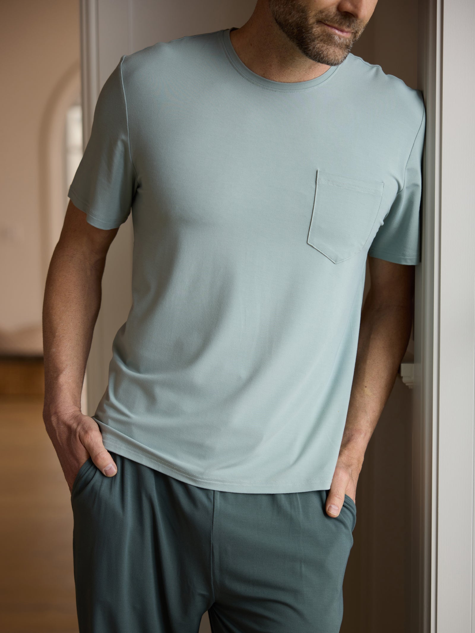 Man wearing haze pajama shirt in hallway 