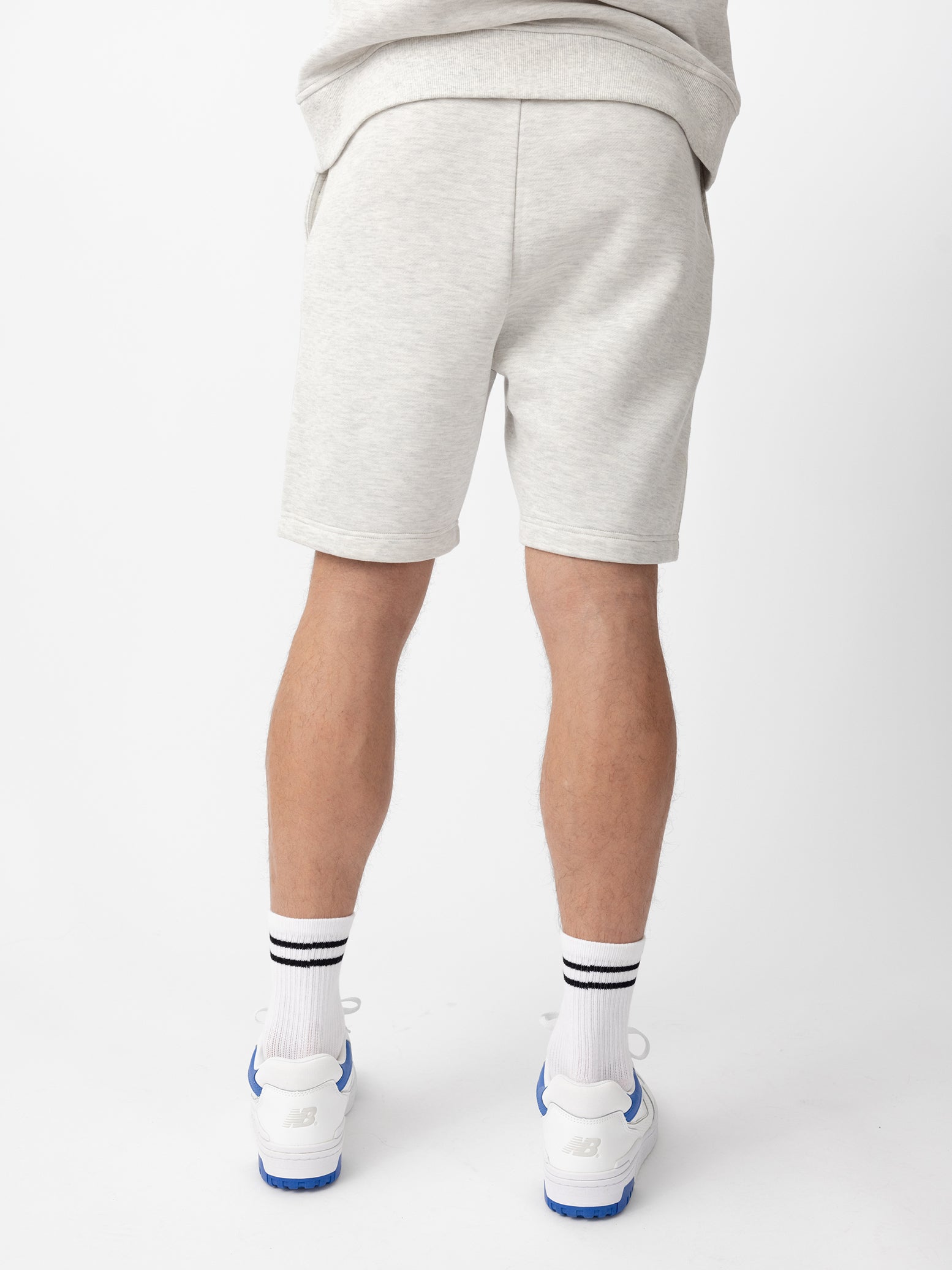 Back of man wearing heather grey cityscape shorts with white background 