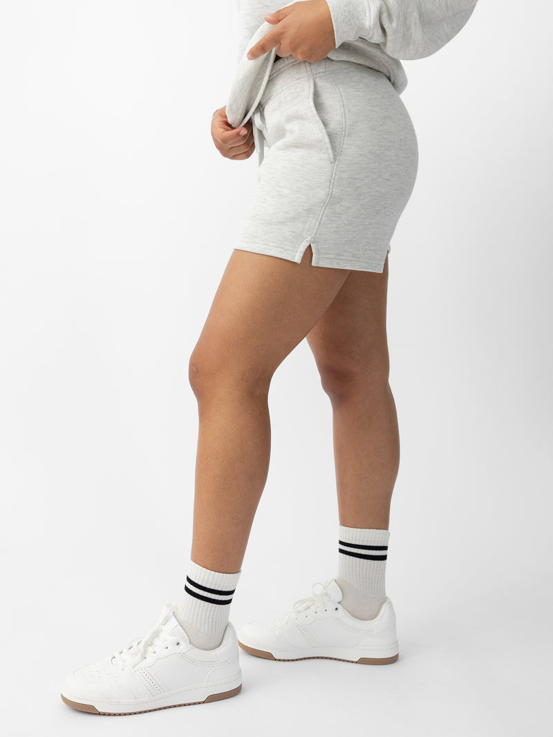 Heather Grey CityScape Shorts. The shorts are being worn by a female model in skate shoes. The background it a white background.
