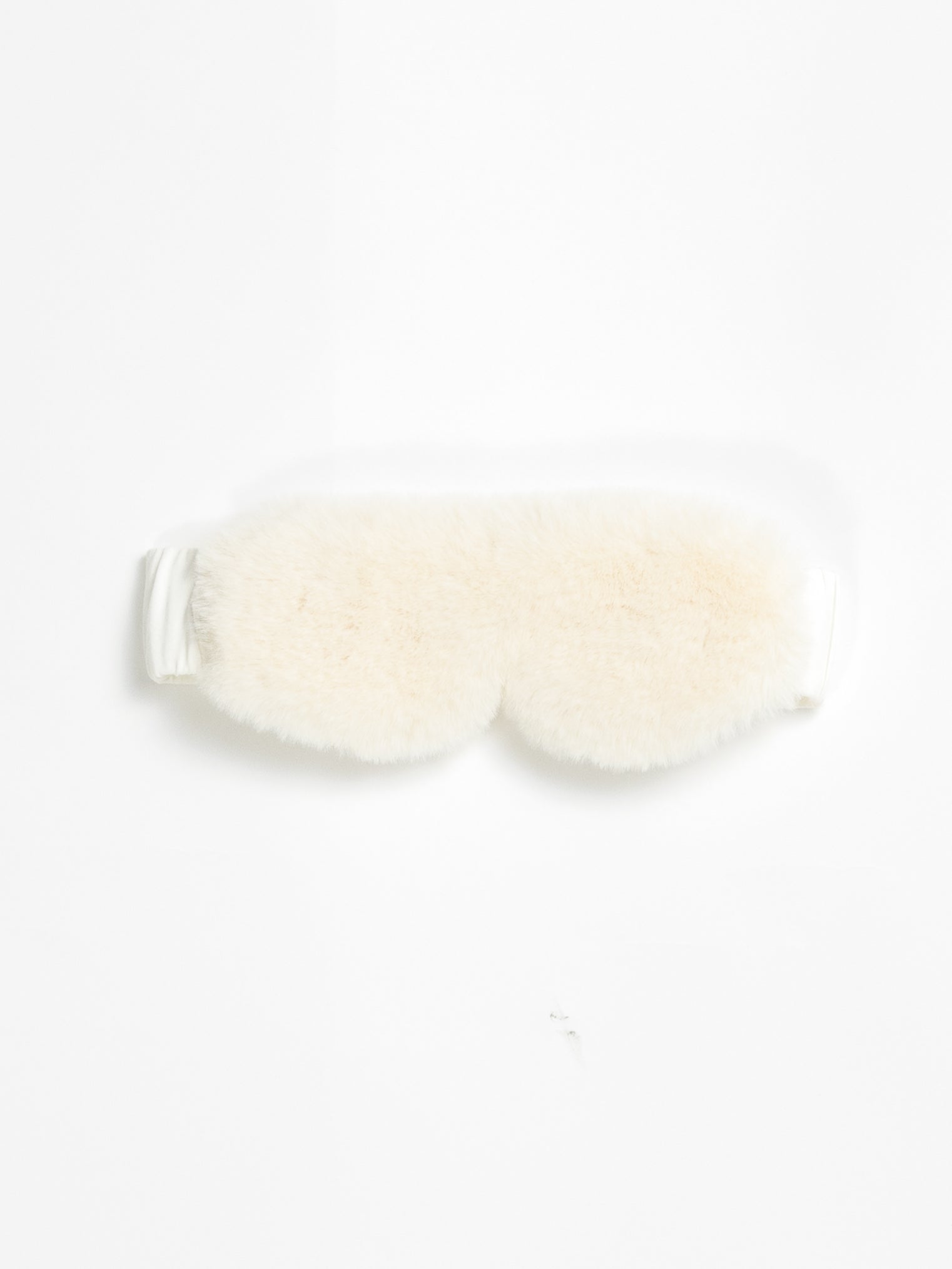 The Cozy Earth Faux Fur Sleep Mask in Ivory is pictured on a white background. 