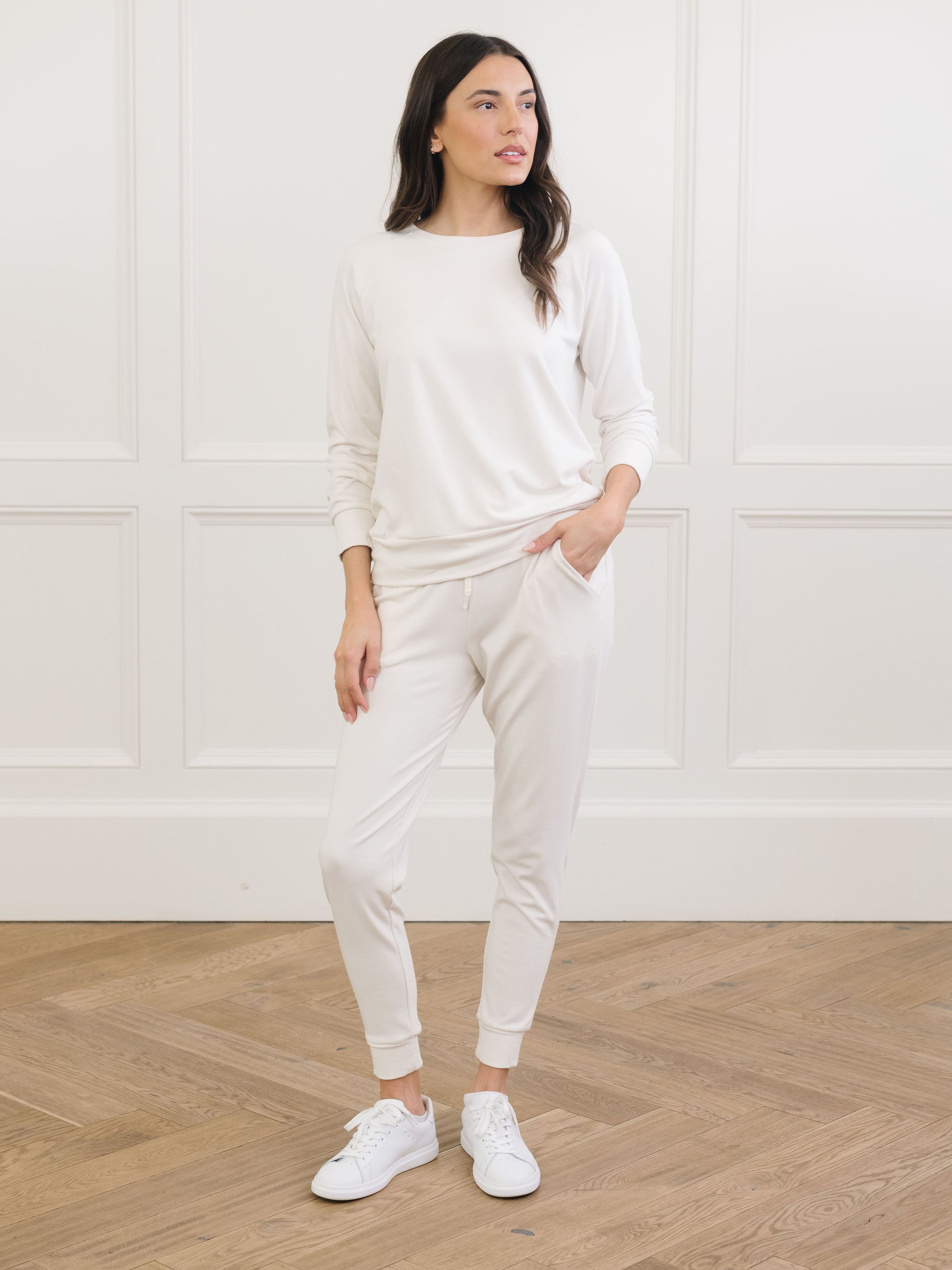 Ivory Bamboo Jogger Set modeled by a woman. The photo was taken in a high contrast setting, showing off the colors and lines of the pajamas. 