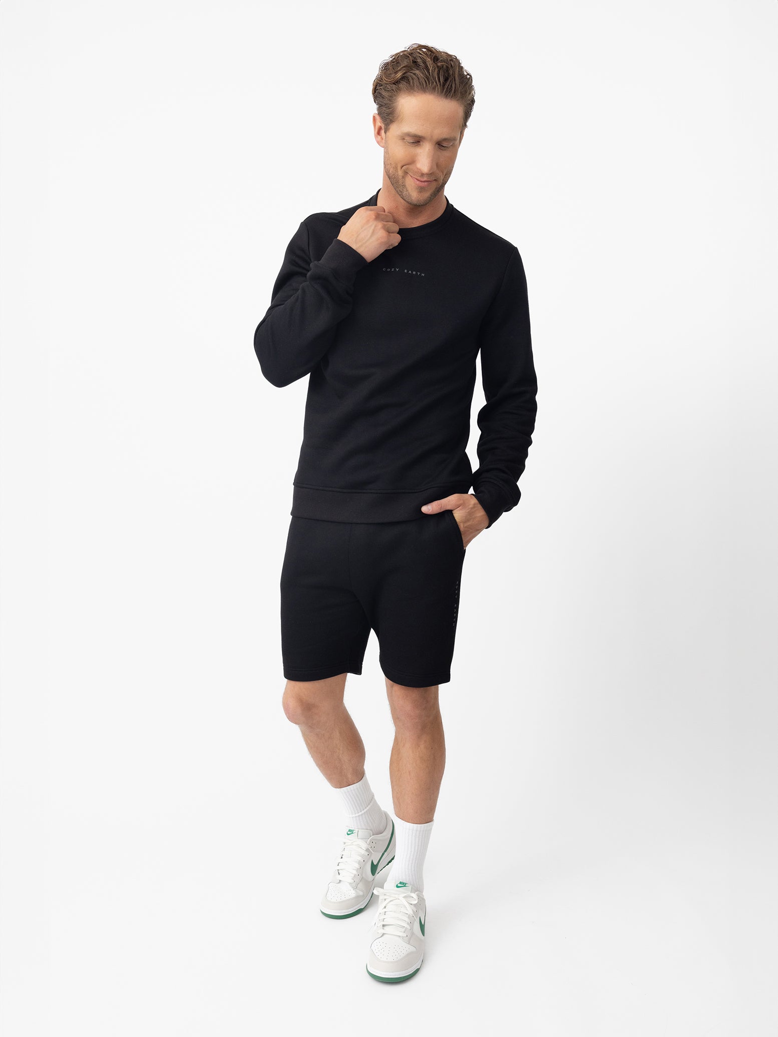Man wearing black cityscape pullover and shorts with white background 