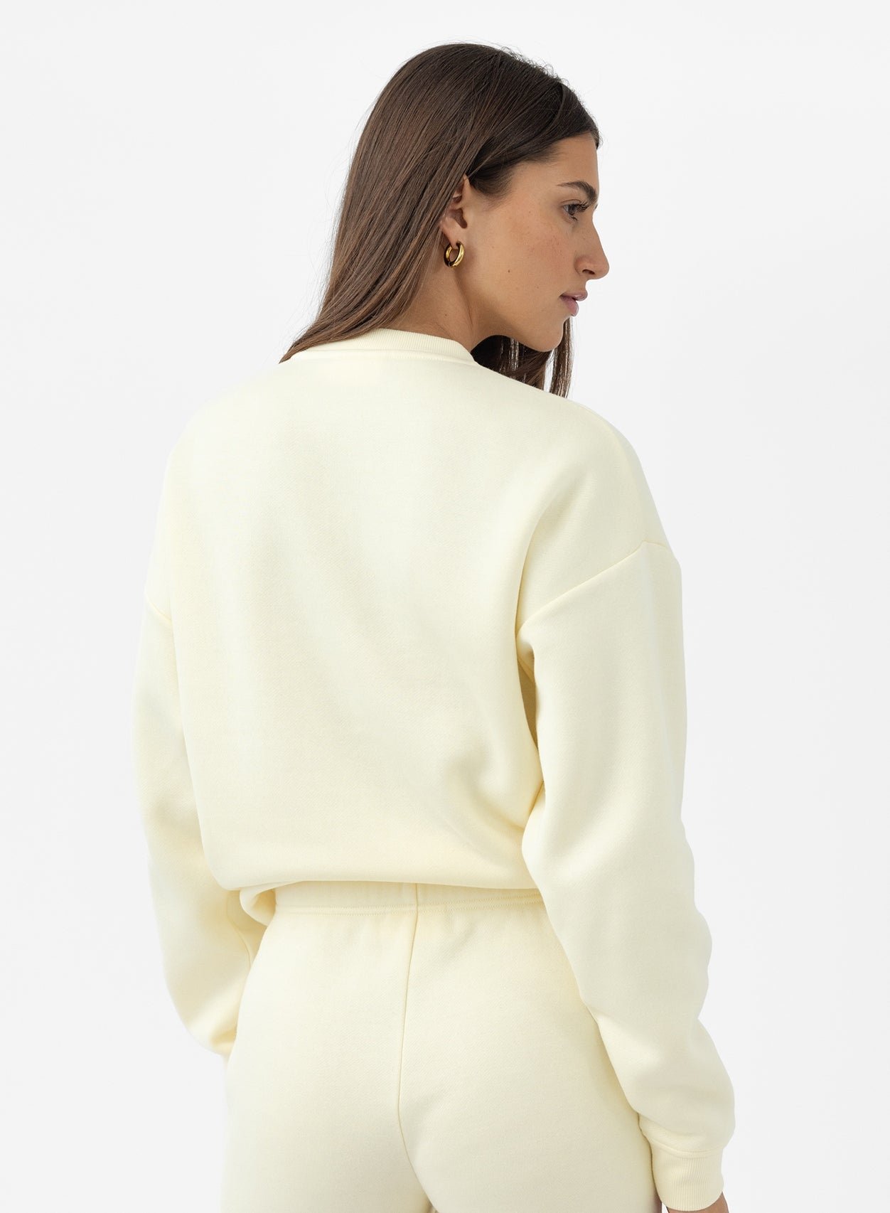 Back of woman wearing lemonade cityscape pullover 