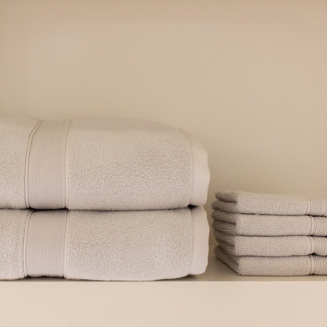 Light grey luxe towels and washcloths folded on shelf 