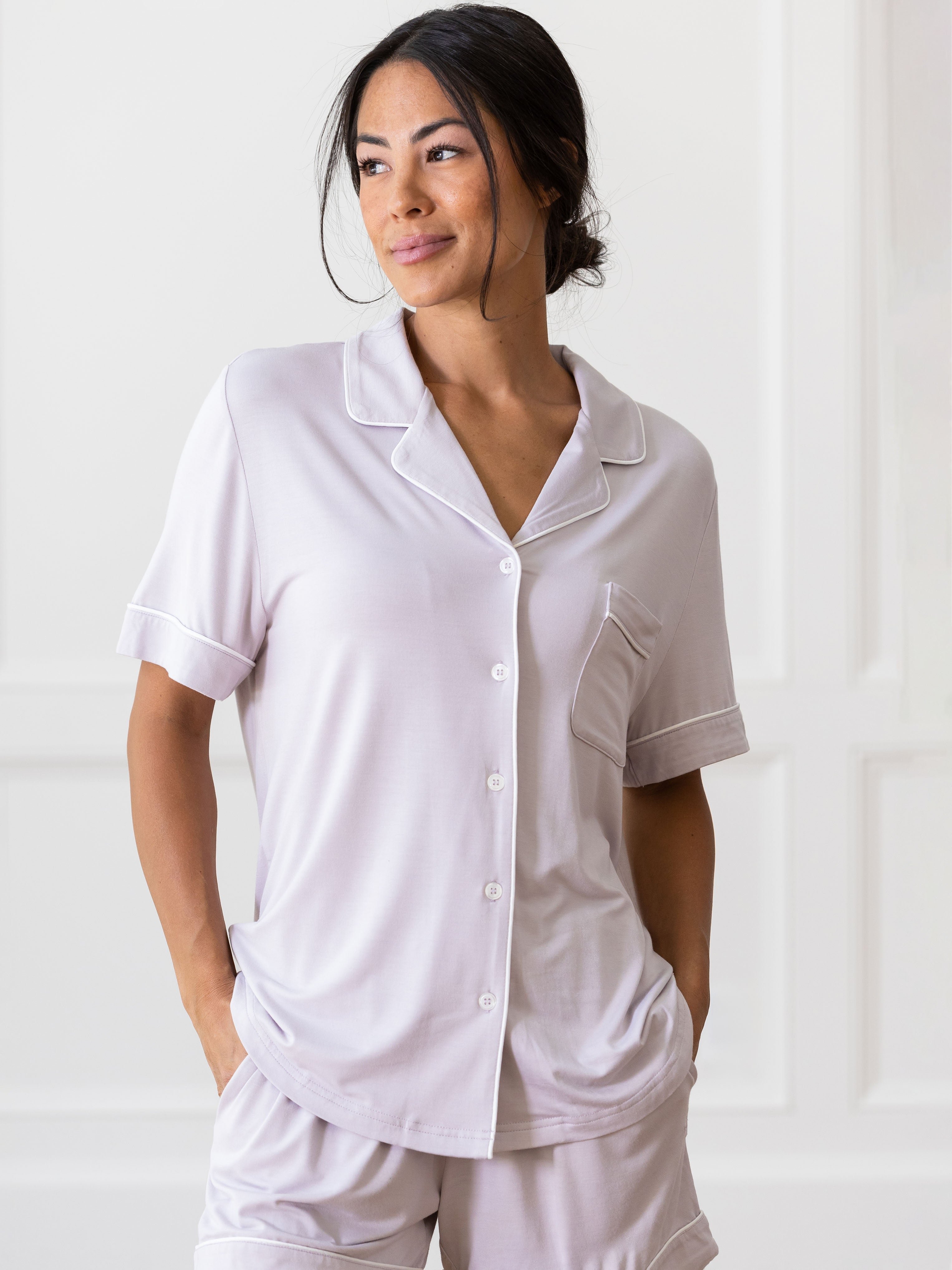 Lilac Short Sleeve Pajama Set modeled by a woman. The photo was taken in a light setting, showing off the colors and lines of the pajamas. 