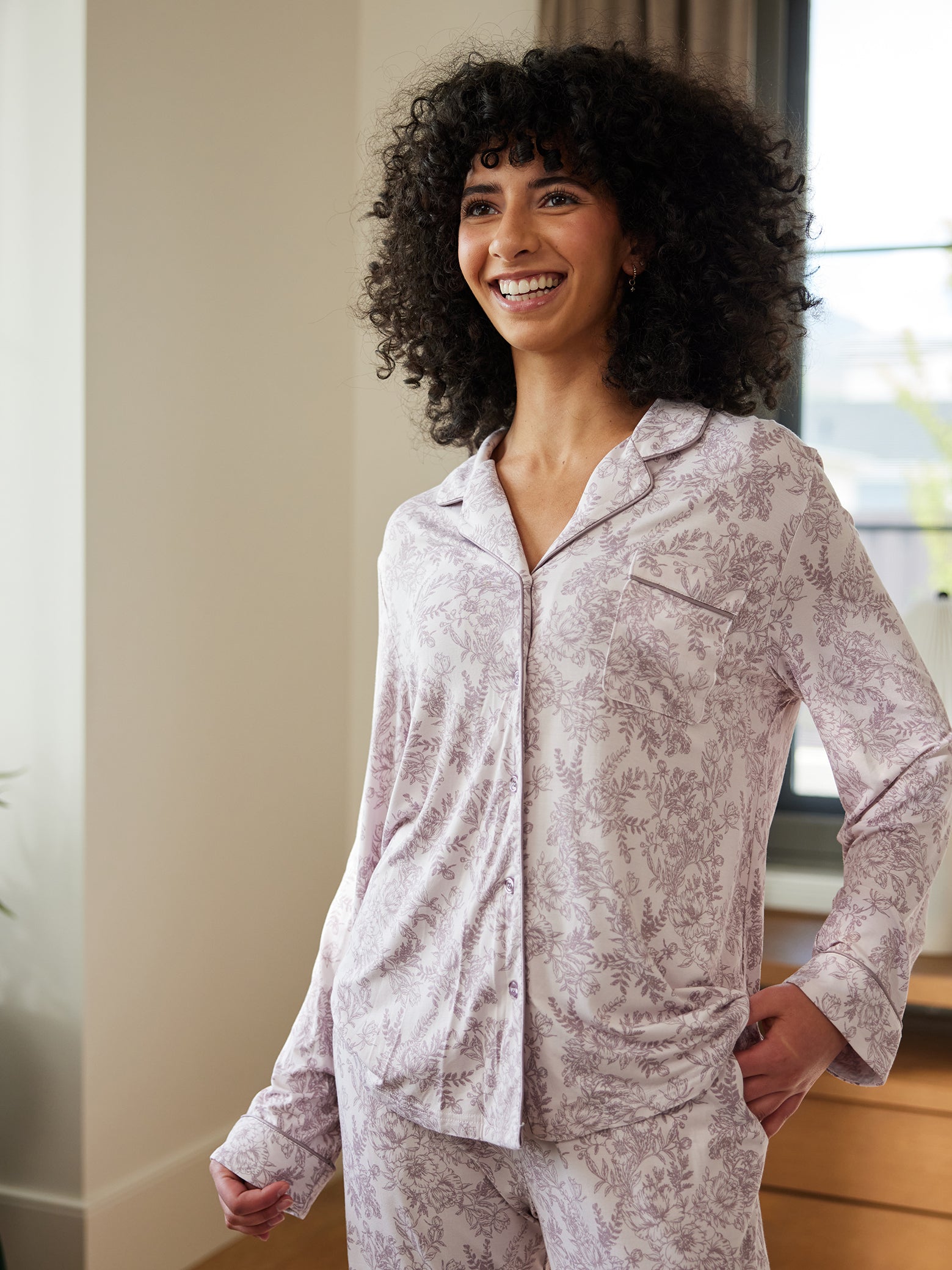Woman smiling wearing lilac toile pajama shirt 
