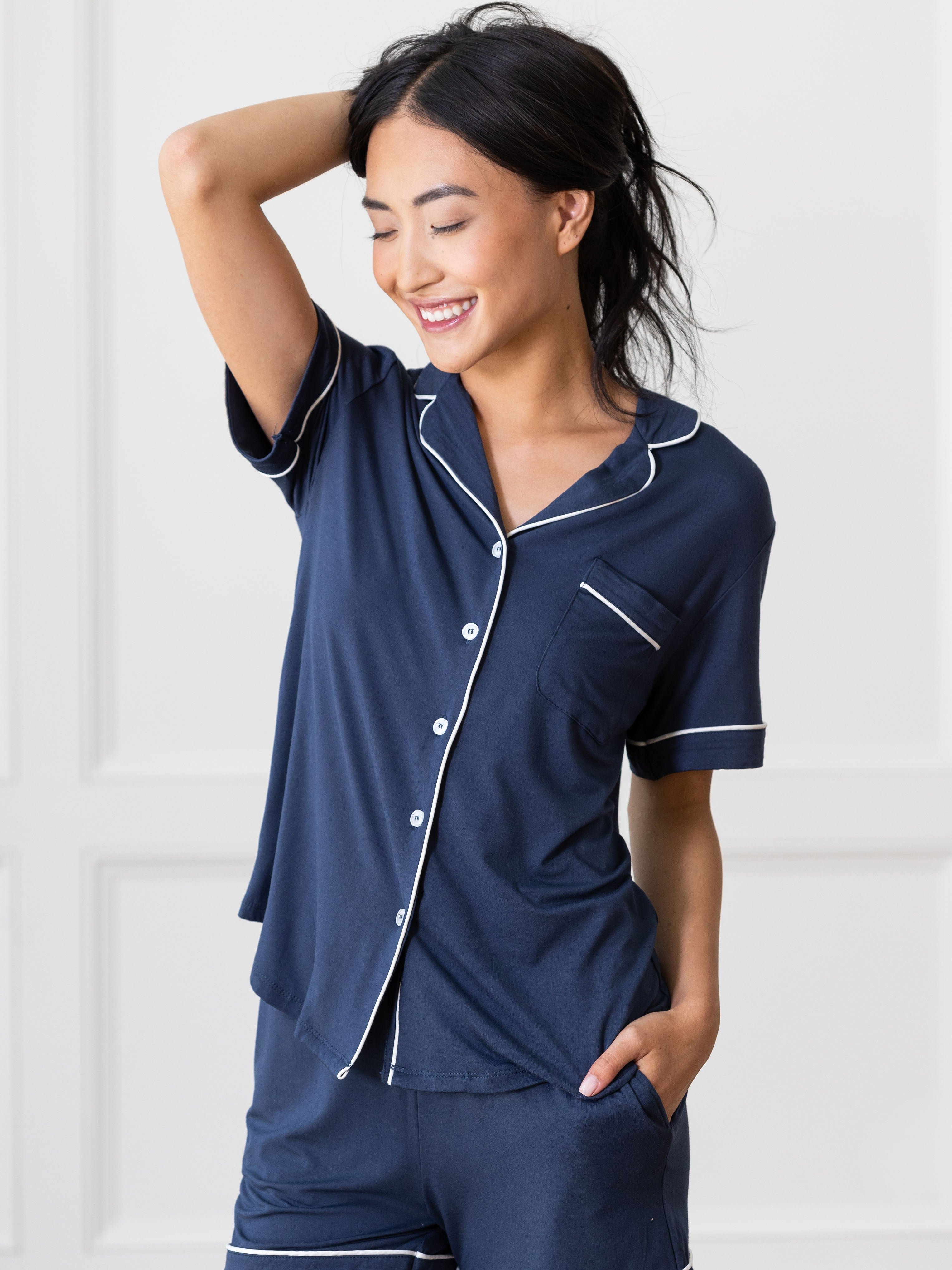 Navy Short Sleeve Pajama Set modeled by a woman. The photo was taken in a light setting, showing off the colors and lines of the pajamas. 