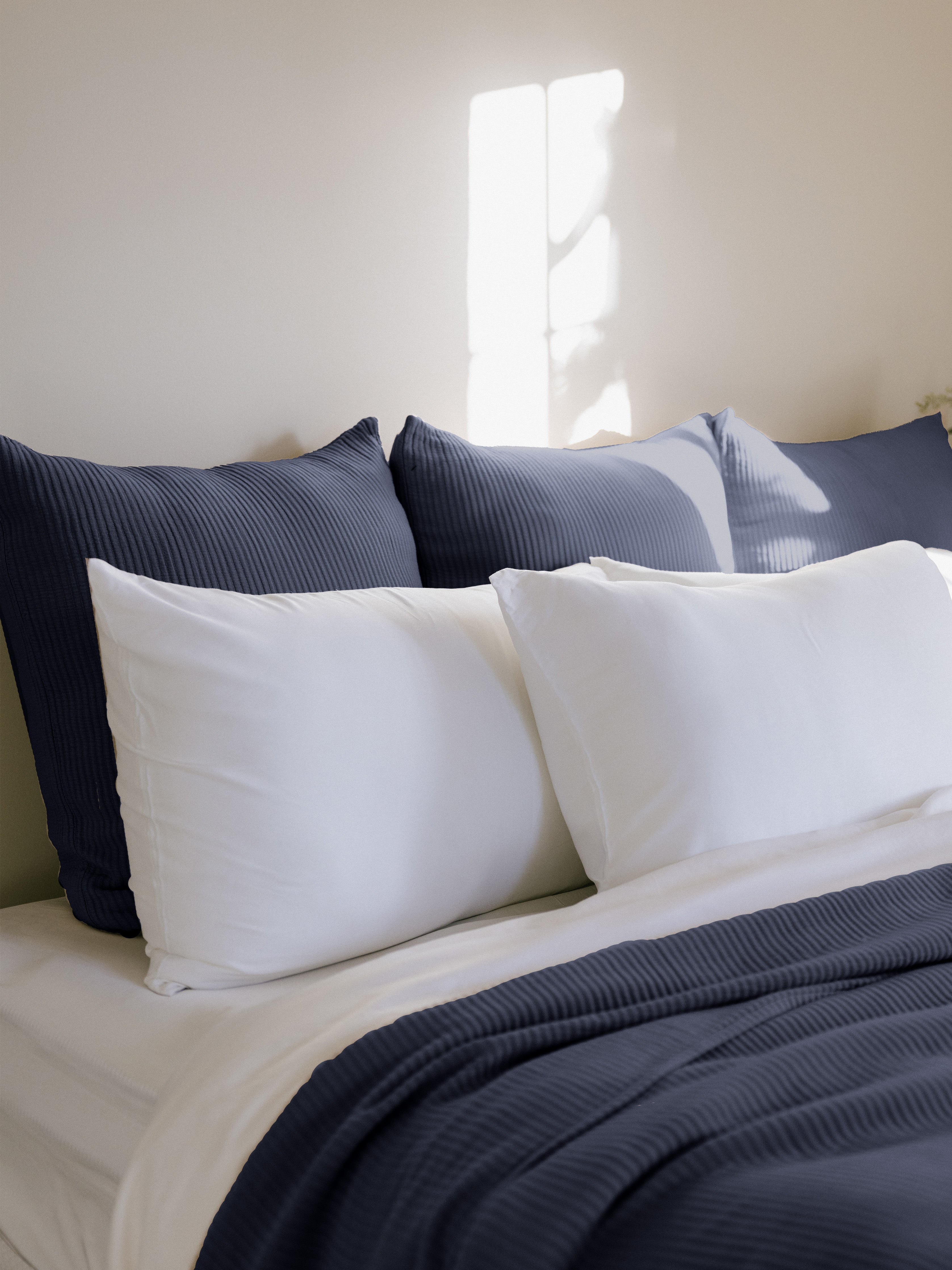 Navy euro coverlet shams behind white pillows on bed |Color:Navy