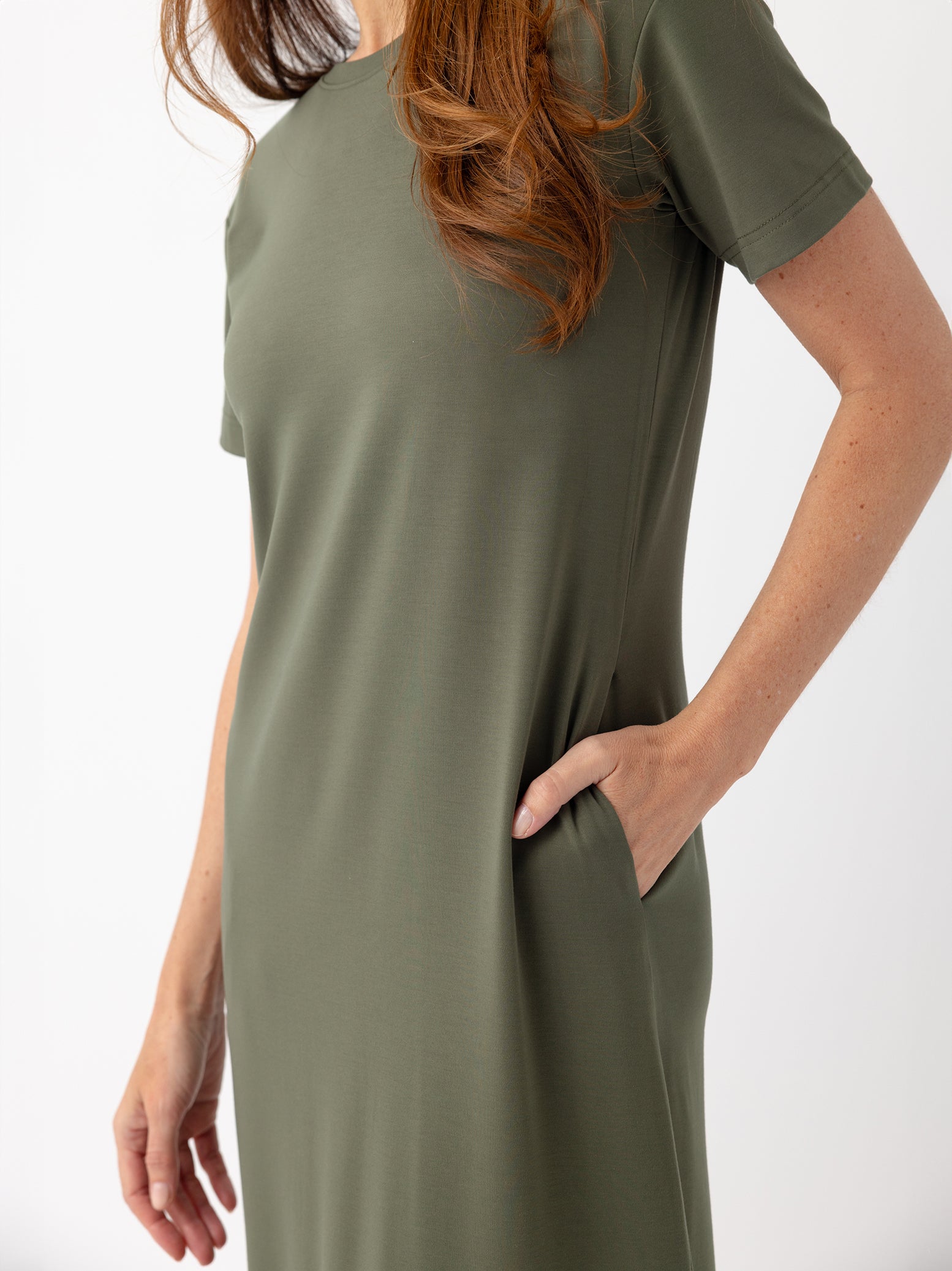 Close up of woman in olive midi dress with white background 