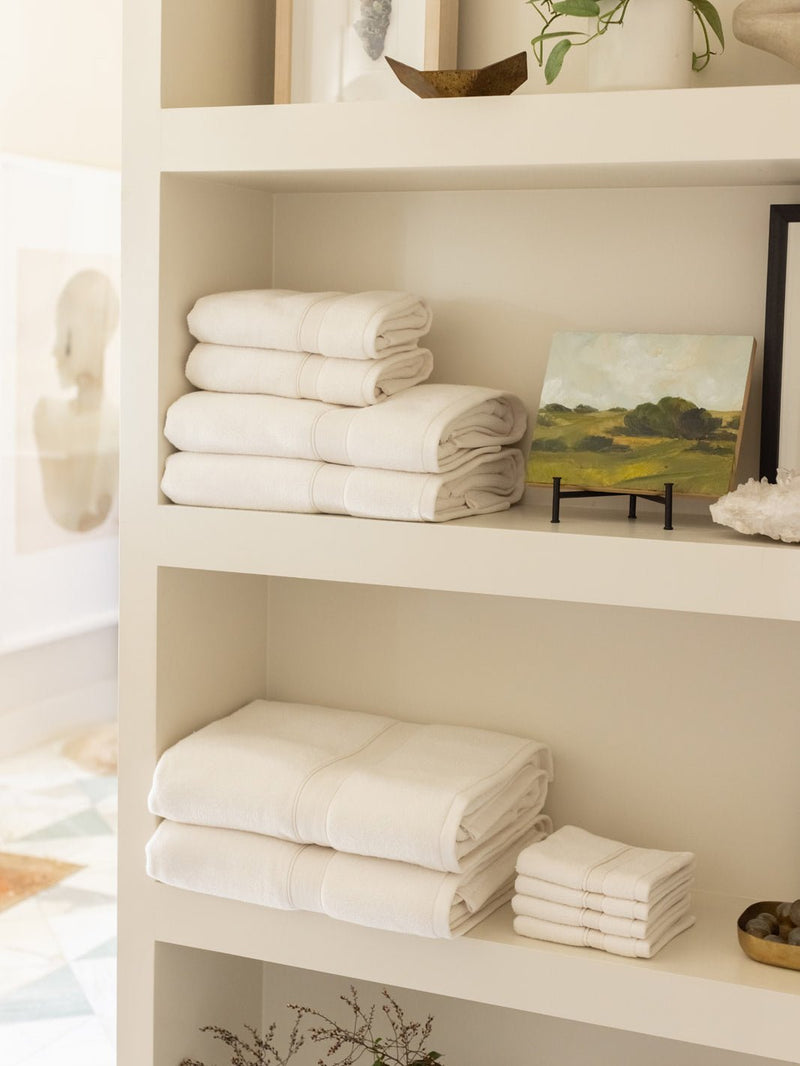 Collection of seashell luxe bath towels folded on shelves