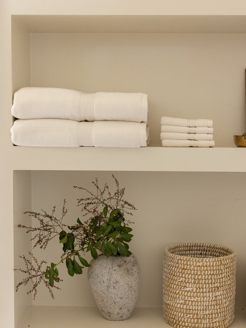 Seashell washcloths and towels folded on shelf