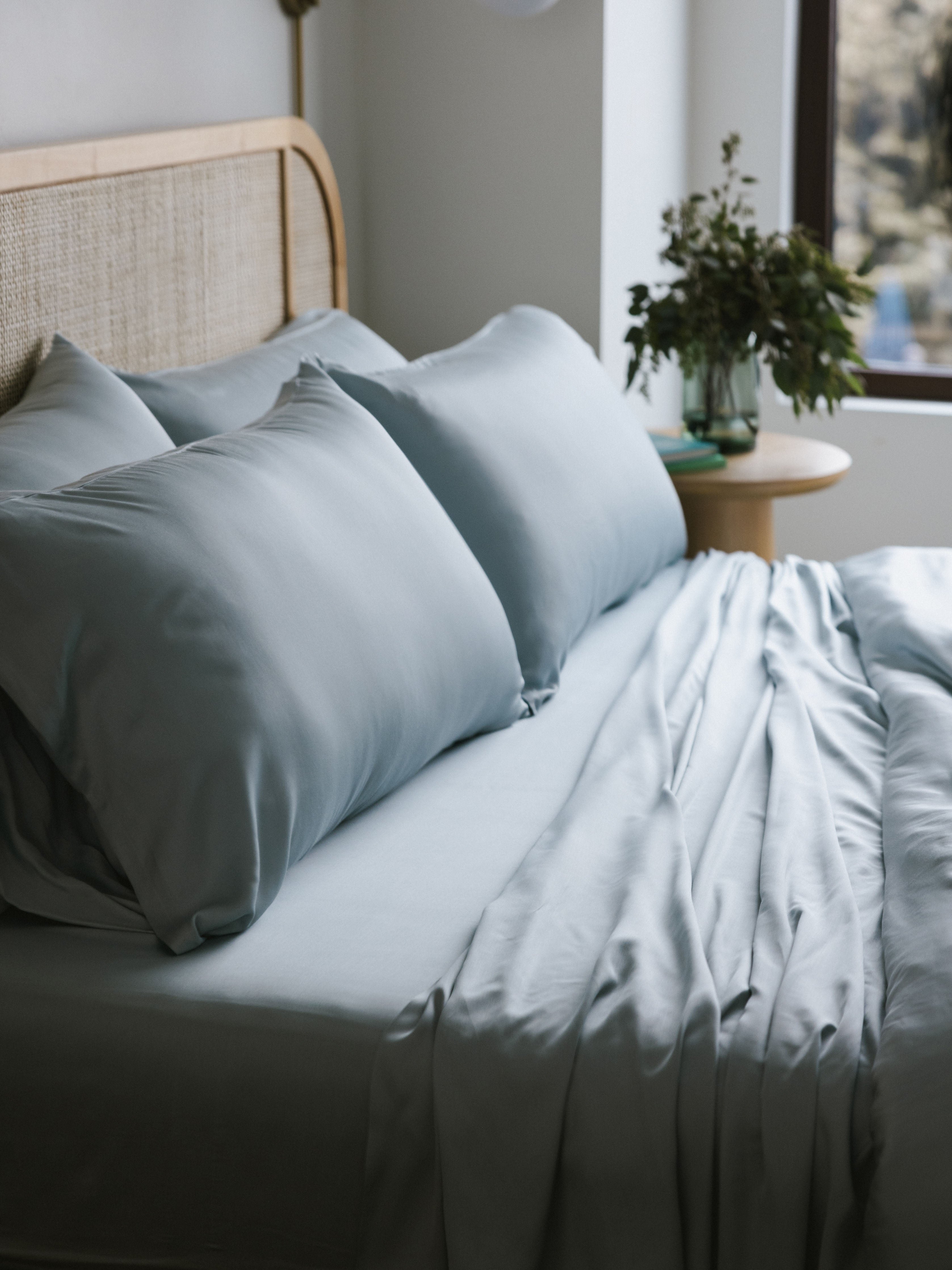 Shore bedding on an unmade bed showing four pillows 