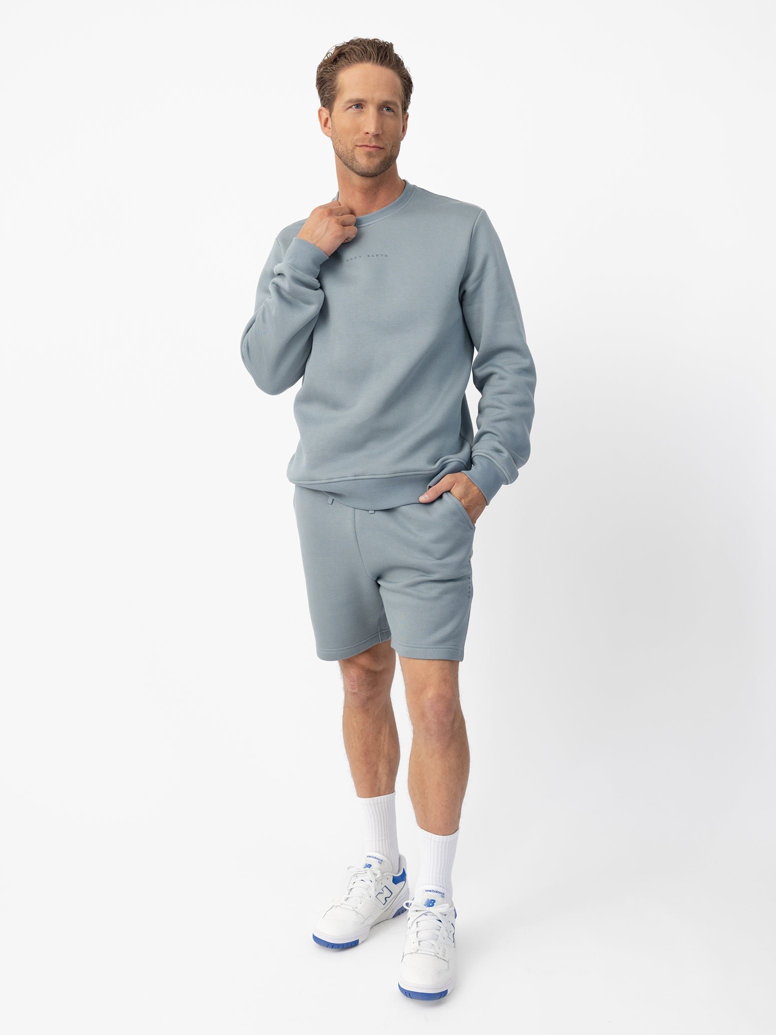 Man wearing Smokey Blue cityscape crewneck with white background 