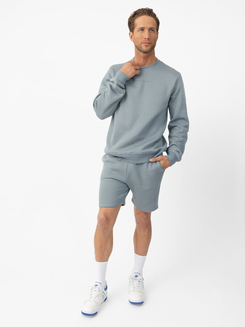 Man wearing Smokey Blue CityScape Shorts with white background
