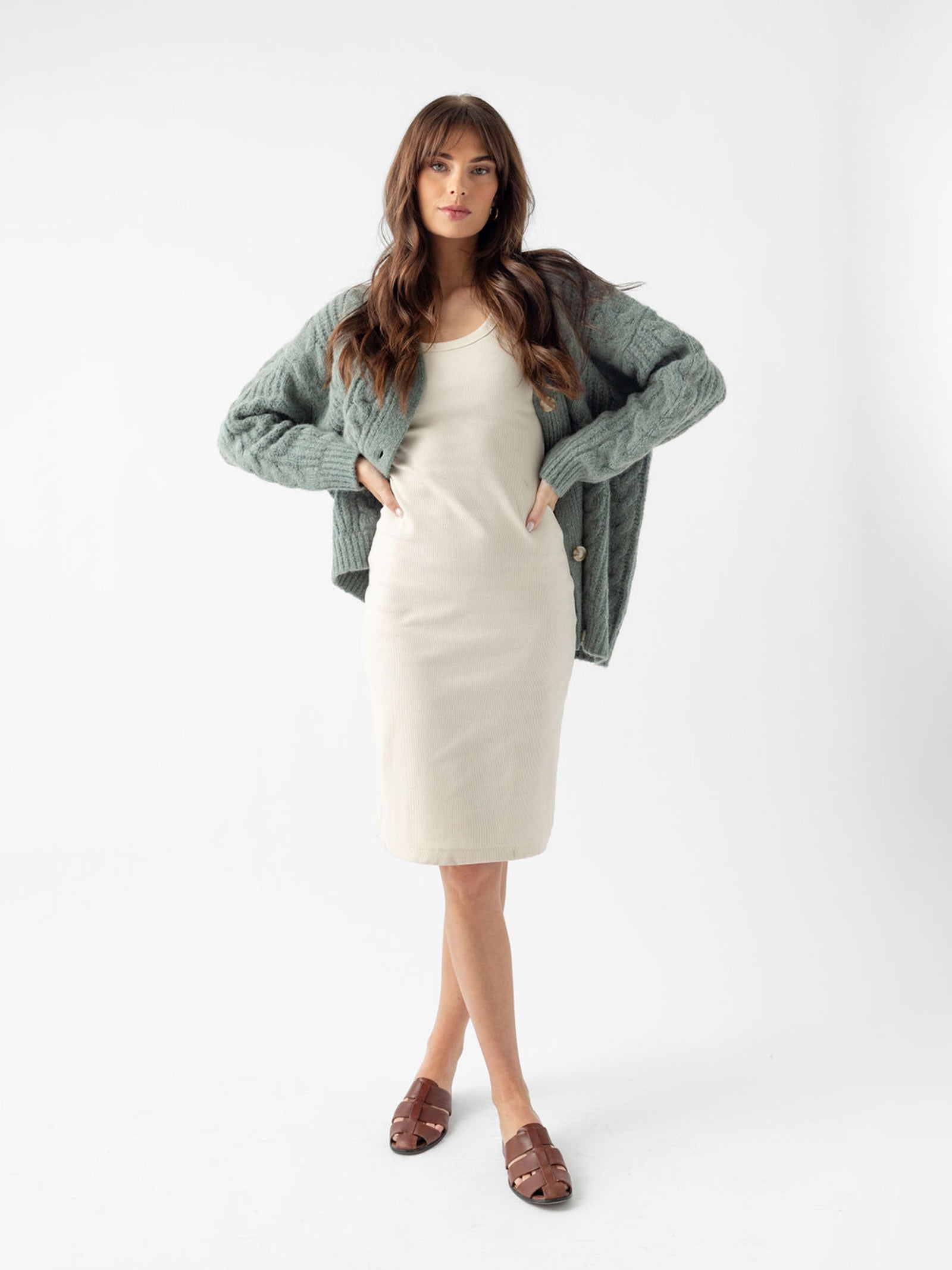 Woman wearing off-white dress with thyme cardigan with white background 