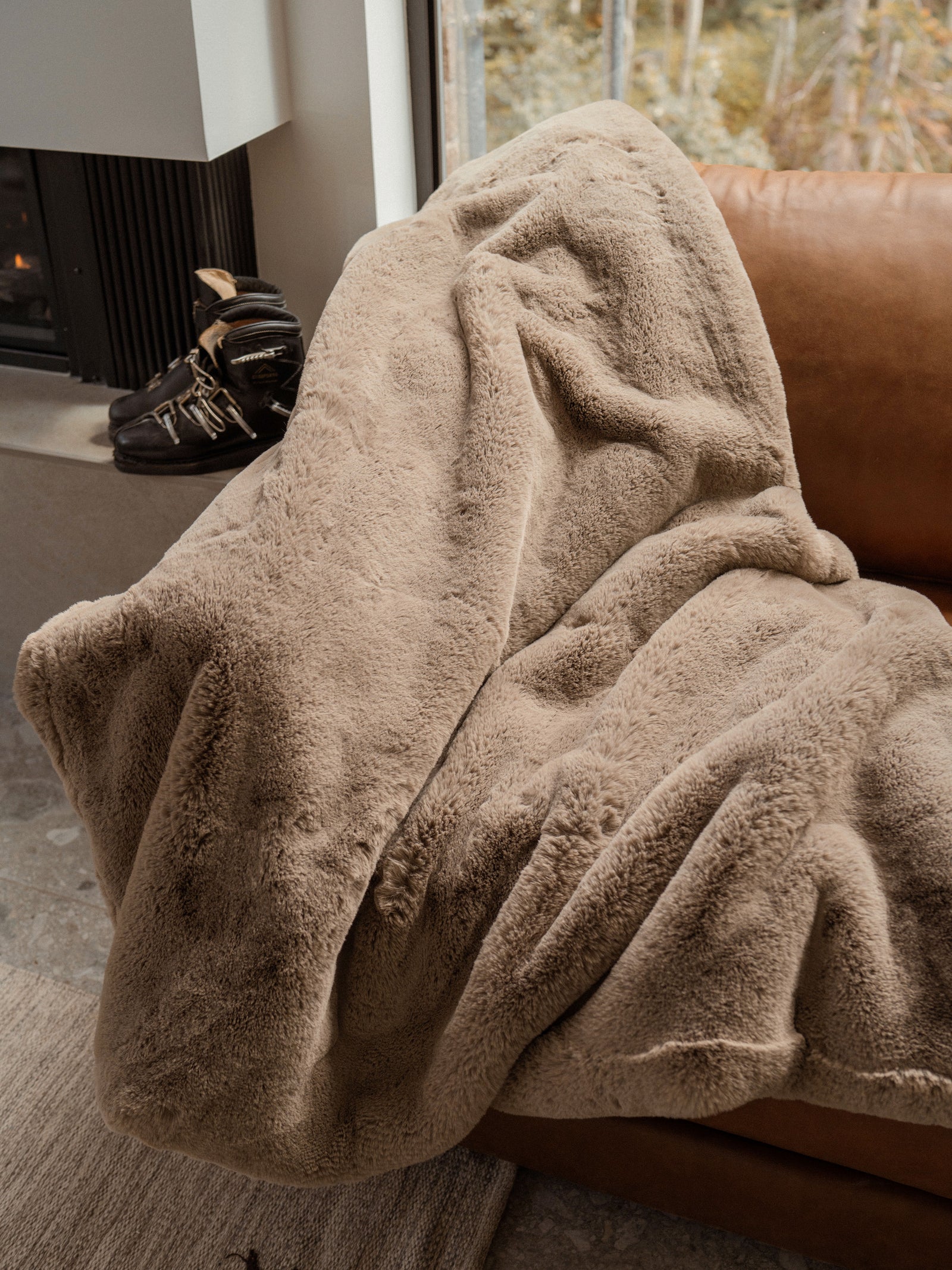 Walnut Oversized Throw Cuddle Blanket draped over couch with ski boots to the side