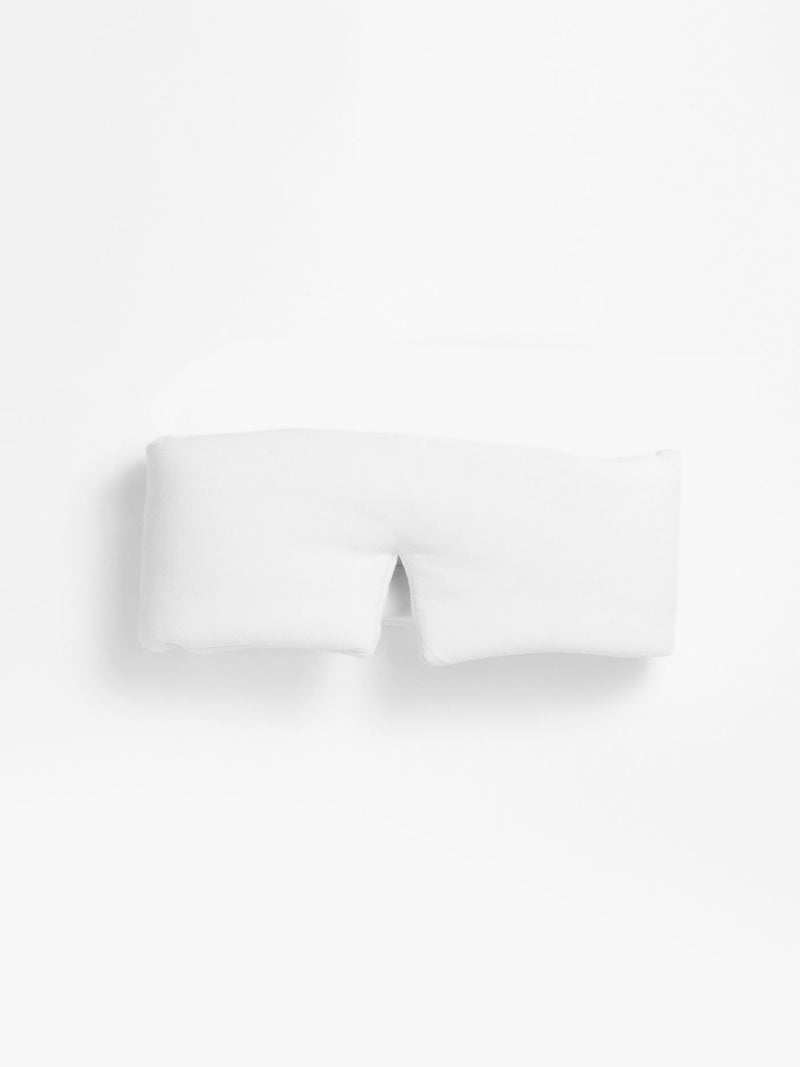 The Cozy Earth Adjustable Bamboo Sleep Mask is shown on a plain white background, featuring a soft rectangular shape with a small U-shaped cutout at one side.