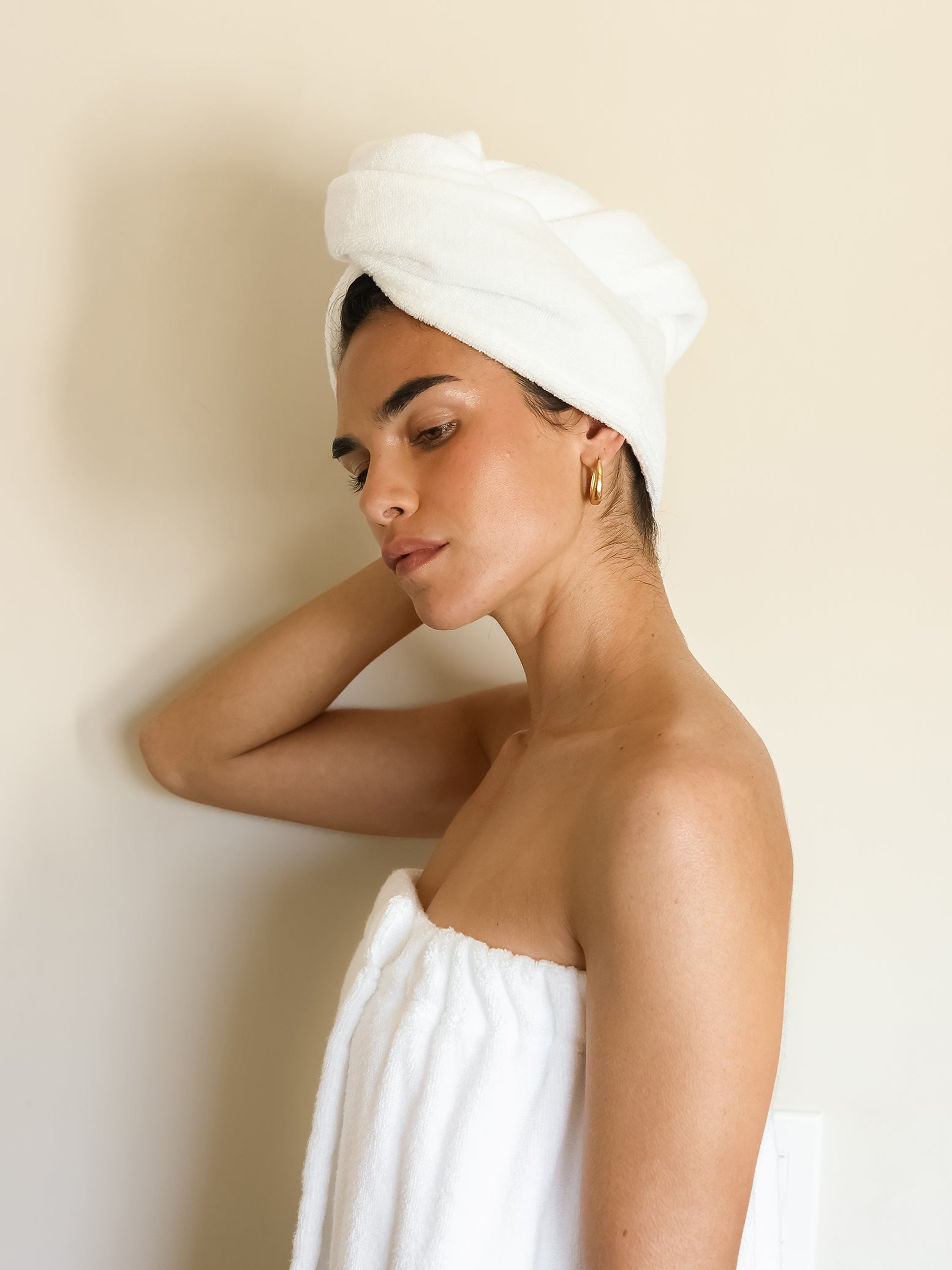 Woman with white hair towel with off-white background 