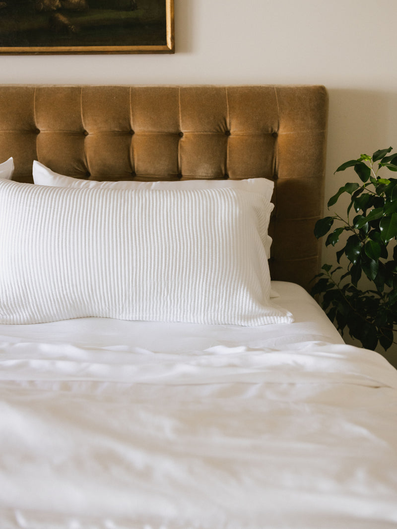 White coverlet sham on white bed