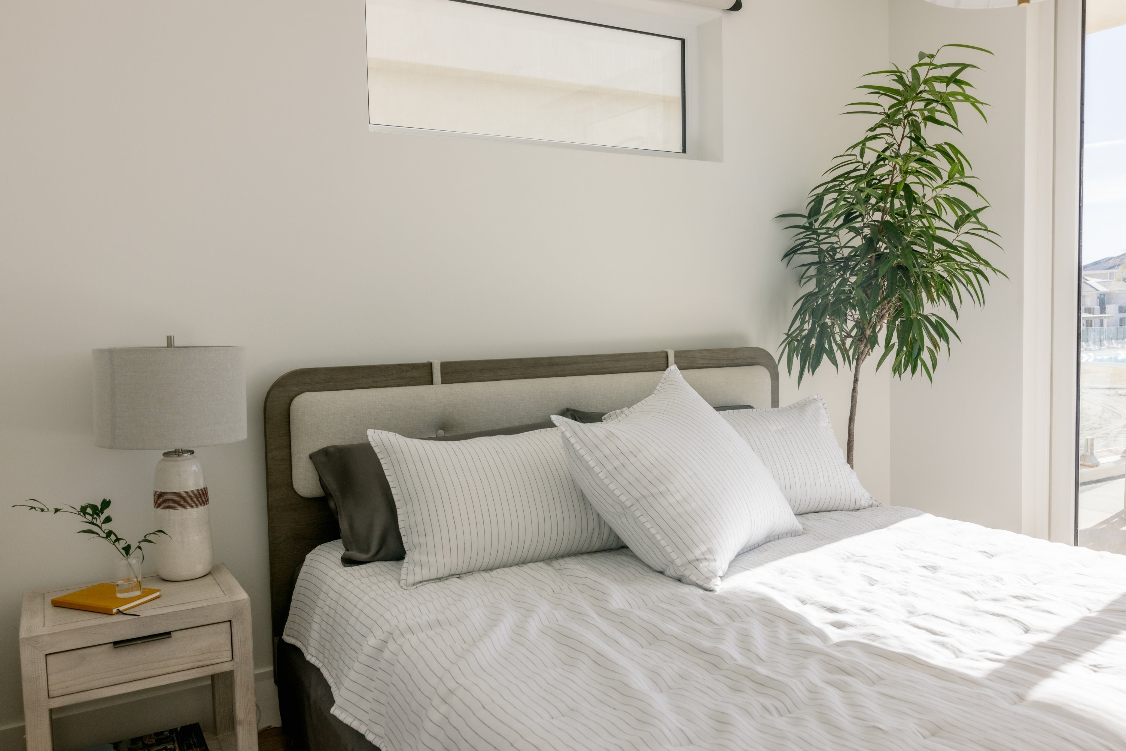 Bed with charcoal pencil stripe quilt and shams 