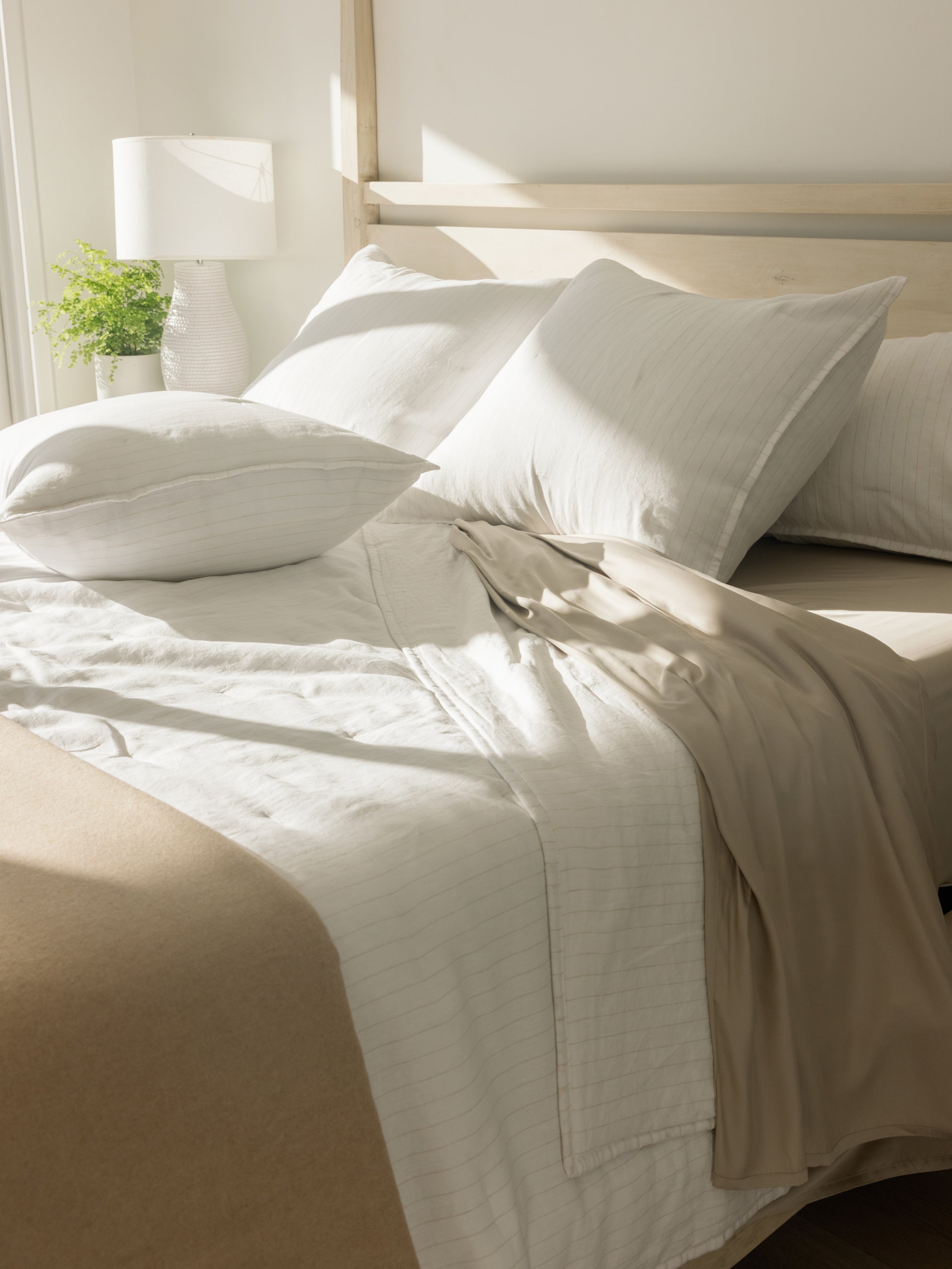 Unmade bed with flax pencil stripe quilt and shams |Color:Flax/White