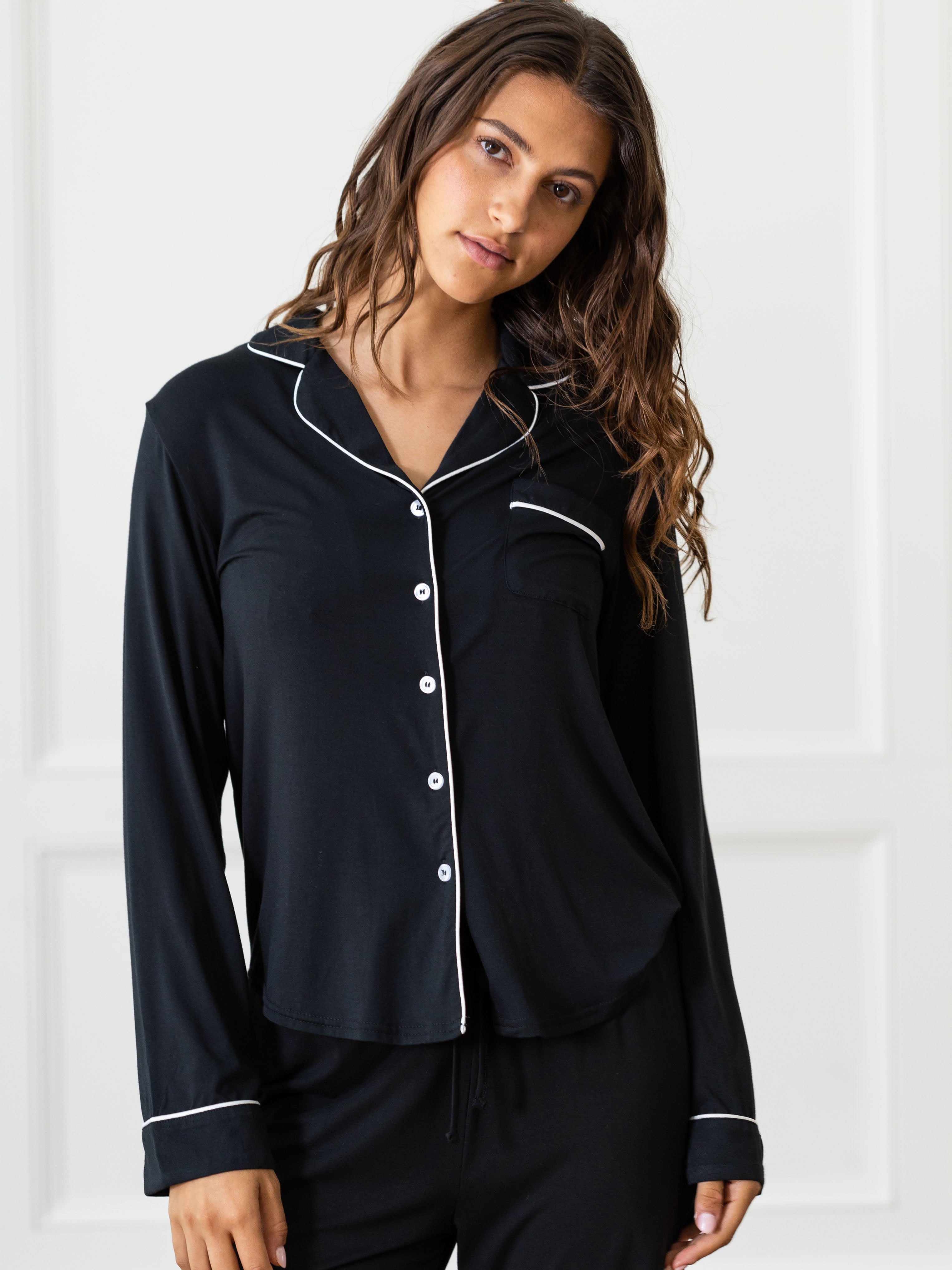 Black Long Sleeve Pajama Set modeled by a woman. The photo was taken in a light setting, showing off the colors and lines of the pajamas. |Color:Black