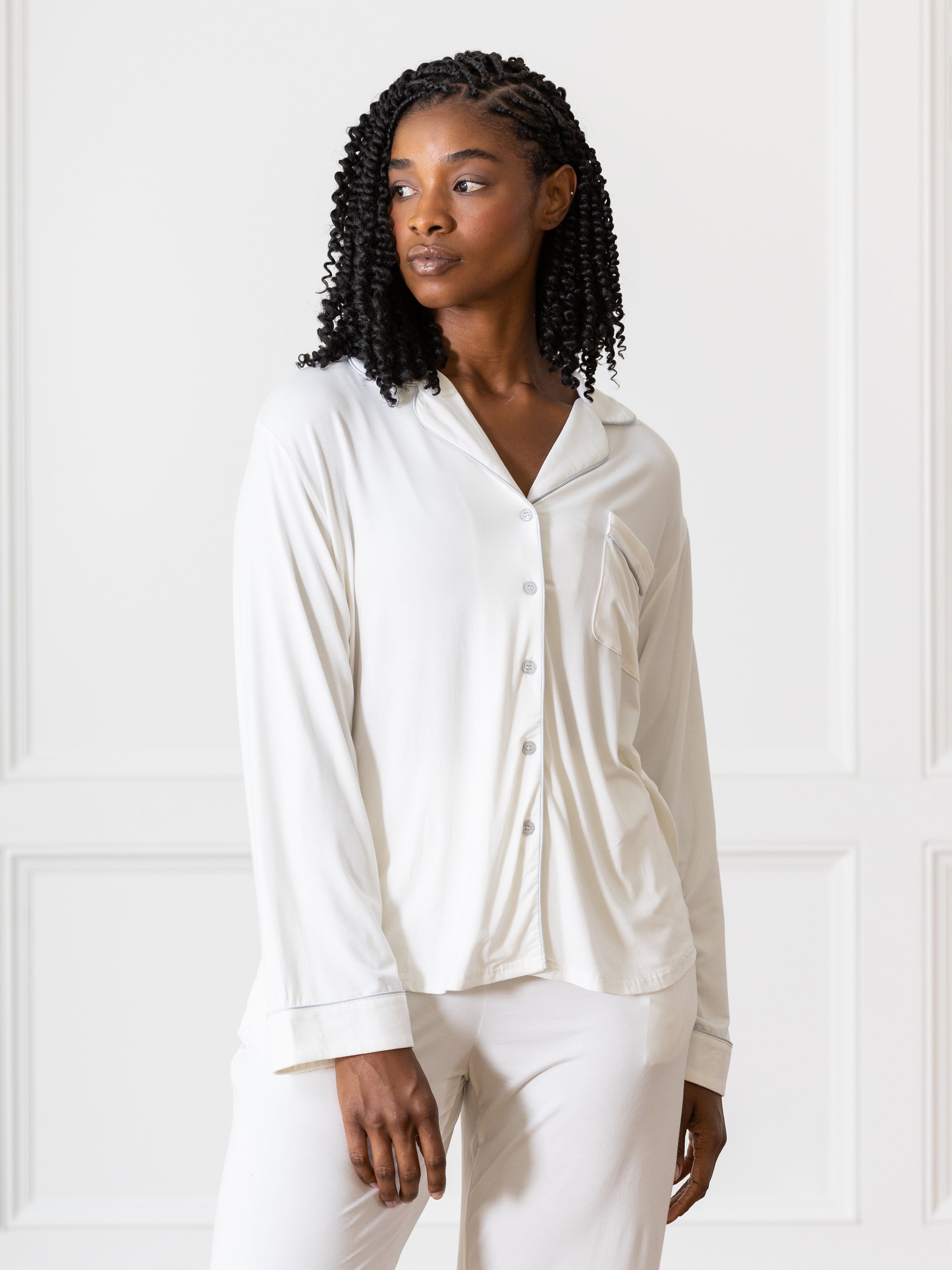 Woman in ivory PJ set in front of white wall 