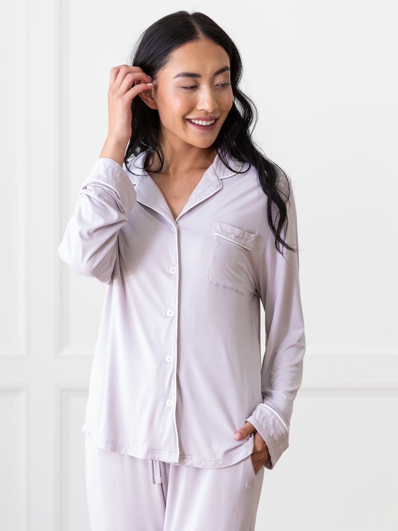 Lilac Long Sleeve Pajama Set modeled by a woman. The photo was taken in a high contrast setting, showing off the colors and lines of the pajamas. 