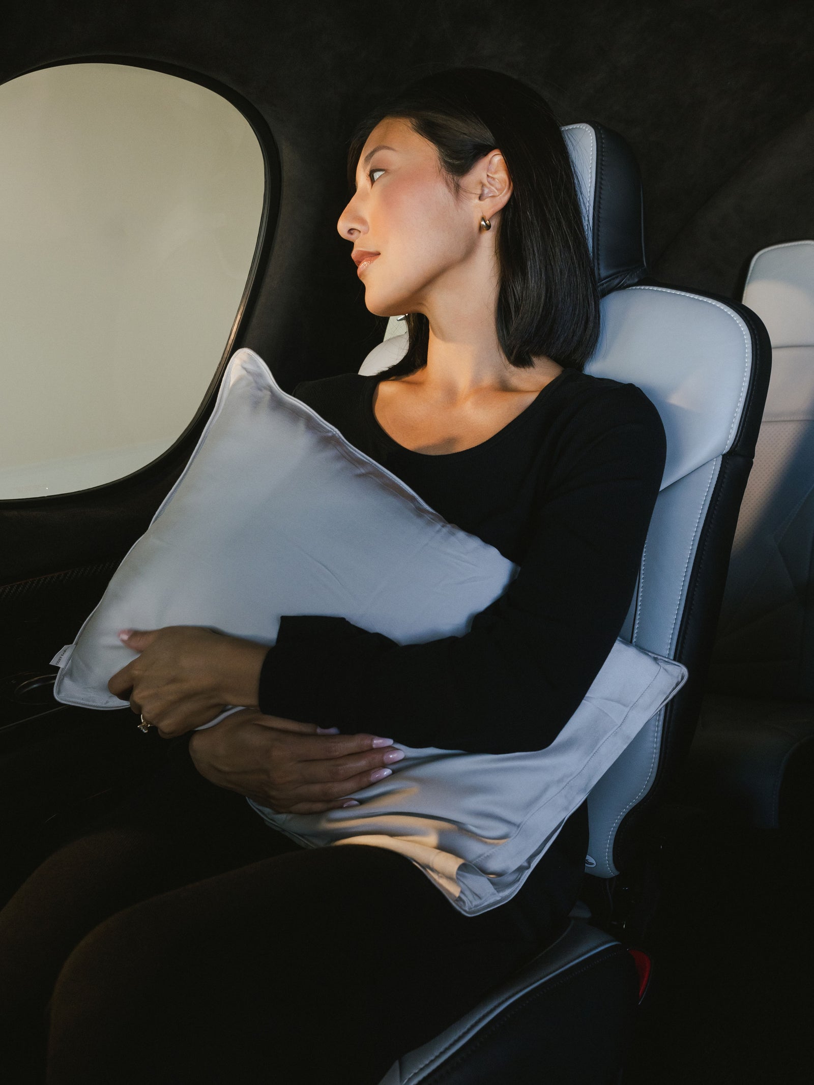 Woman holding travel pillow in airplane 