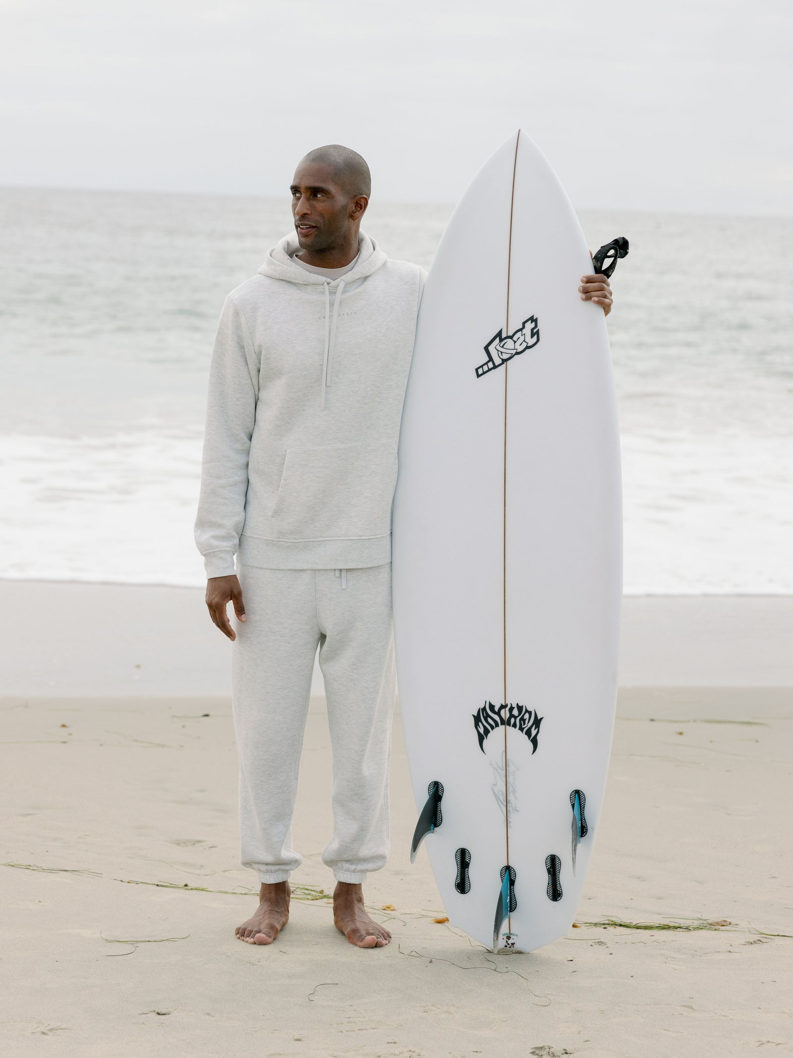 Man on beach wearing heather grey cityscape hoodie set 