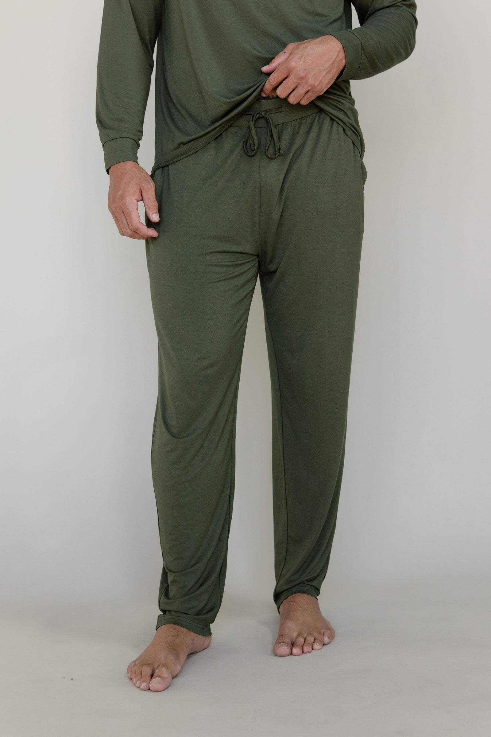 Man in olive long sleeve pajama pants with white background 