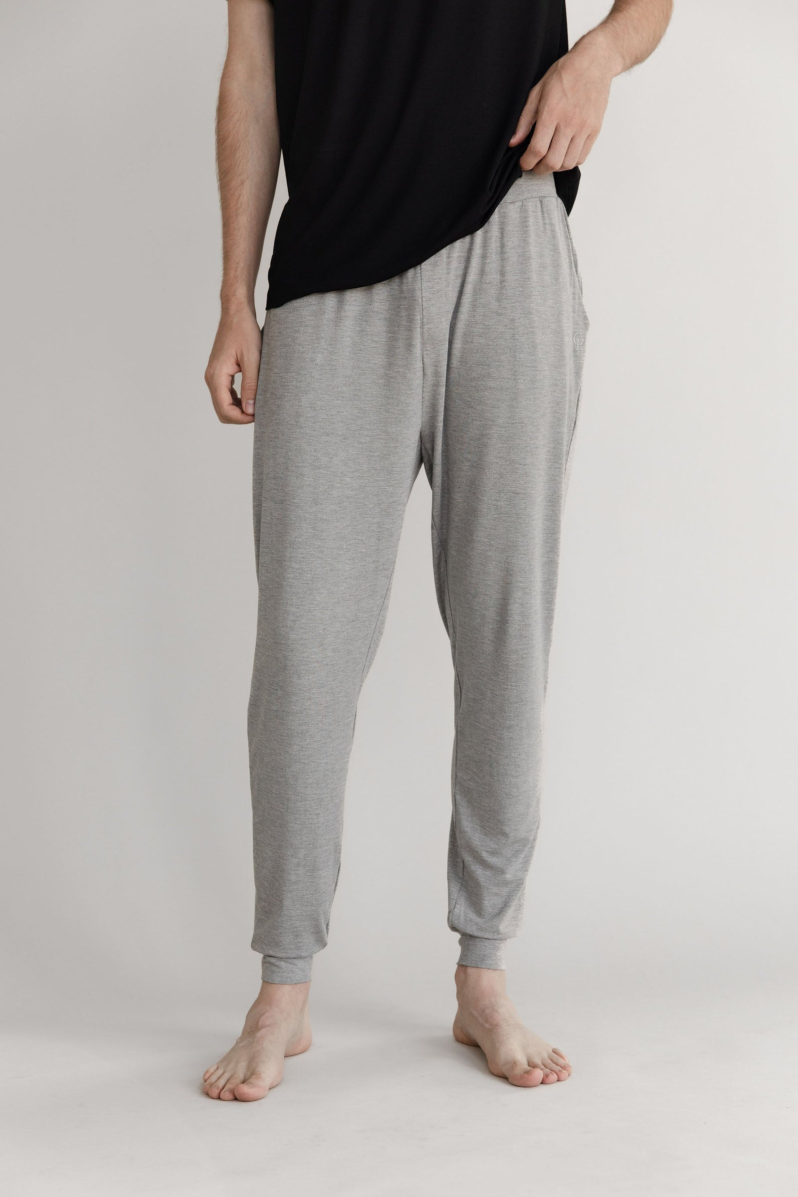 Man in heather grey pajama joggers with white background 