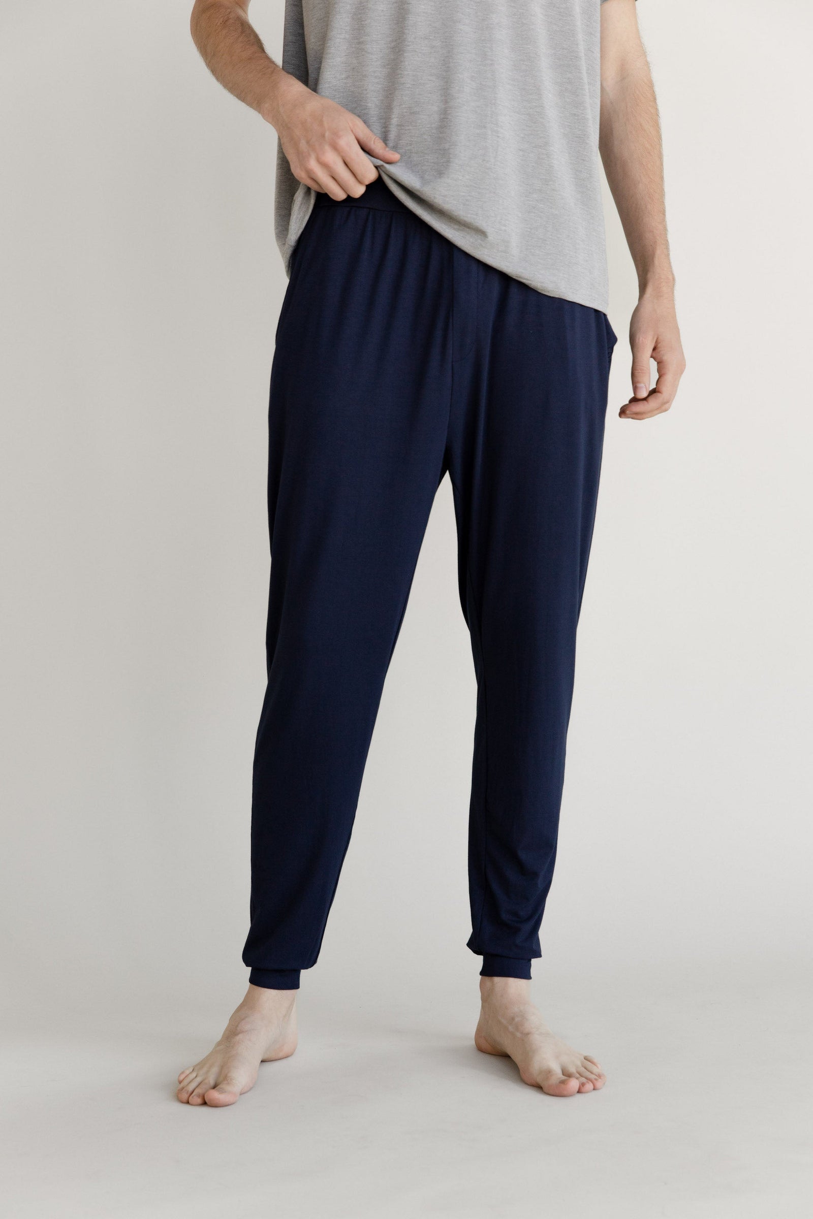 Man in navy pajama joggers with white background 