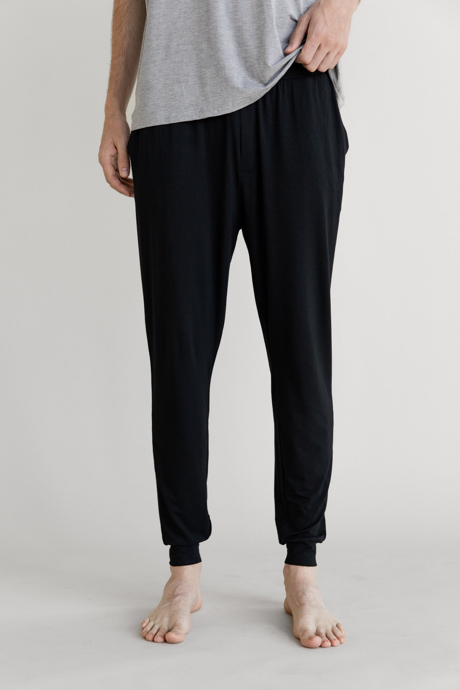 Man in black pajama joggers with white background 