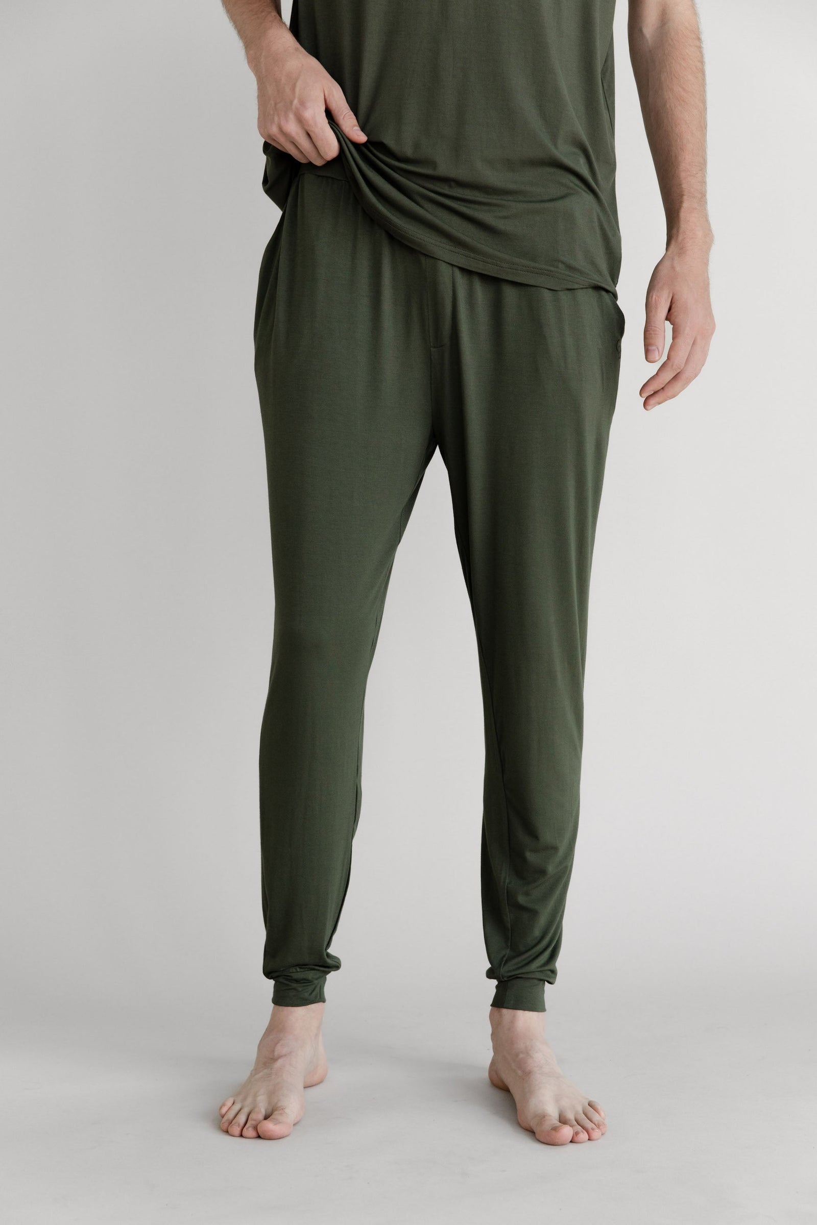 Man in olive pajama joggers with white background 