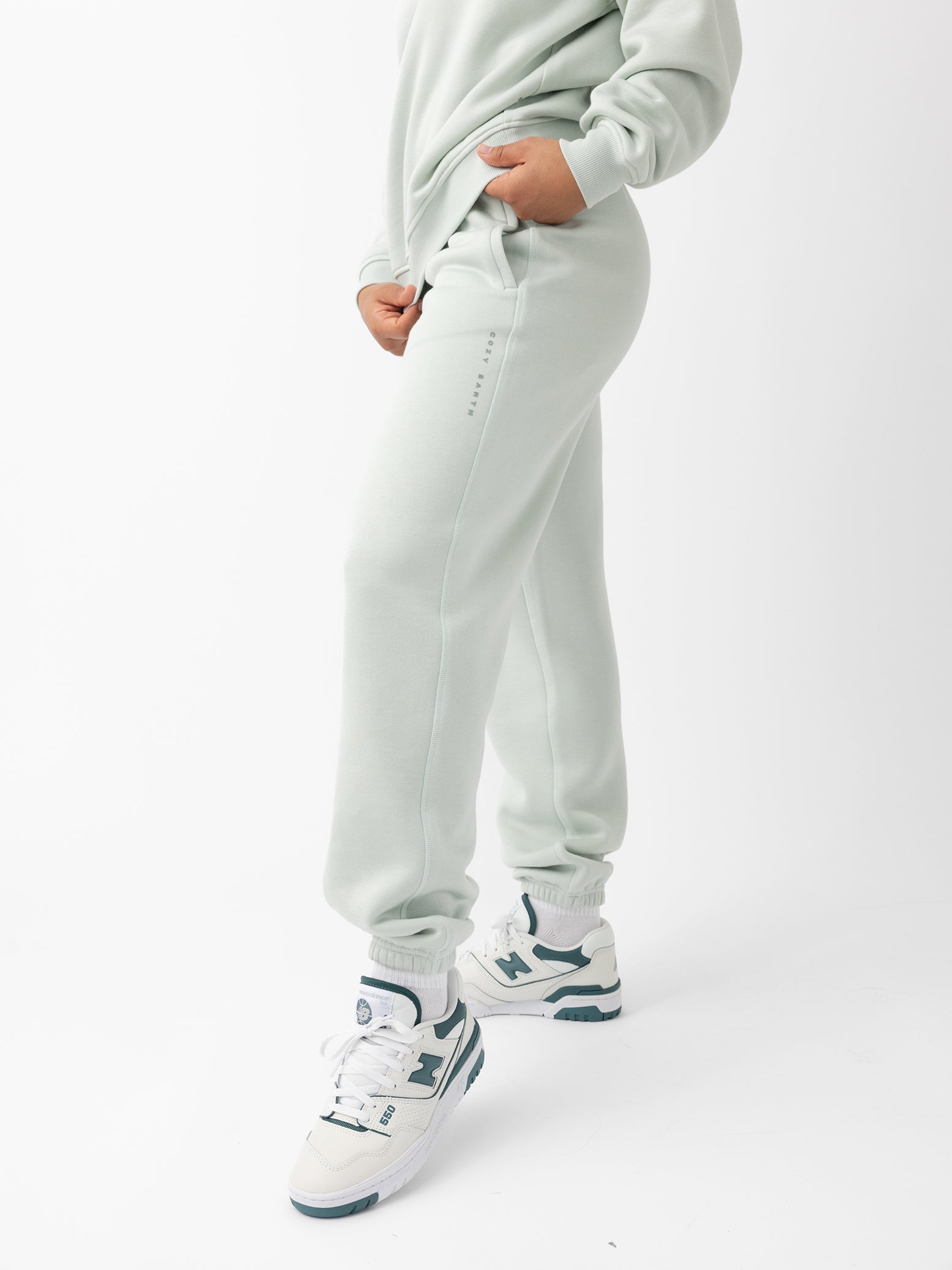 Arctic CityScape Joggers. The Joggers are being worn by a female model. The photo is taken with the models hand by the pocket of the joggers. The back ground is a crisp white background. |Color:Arctic