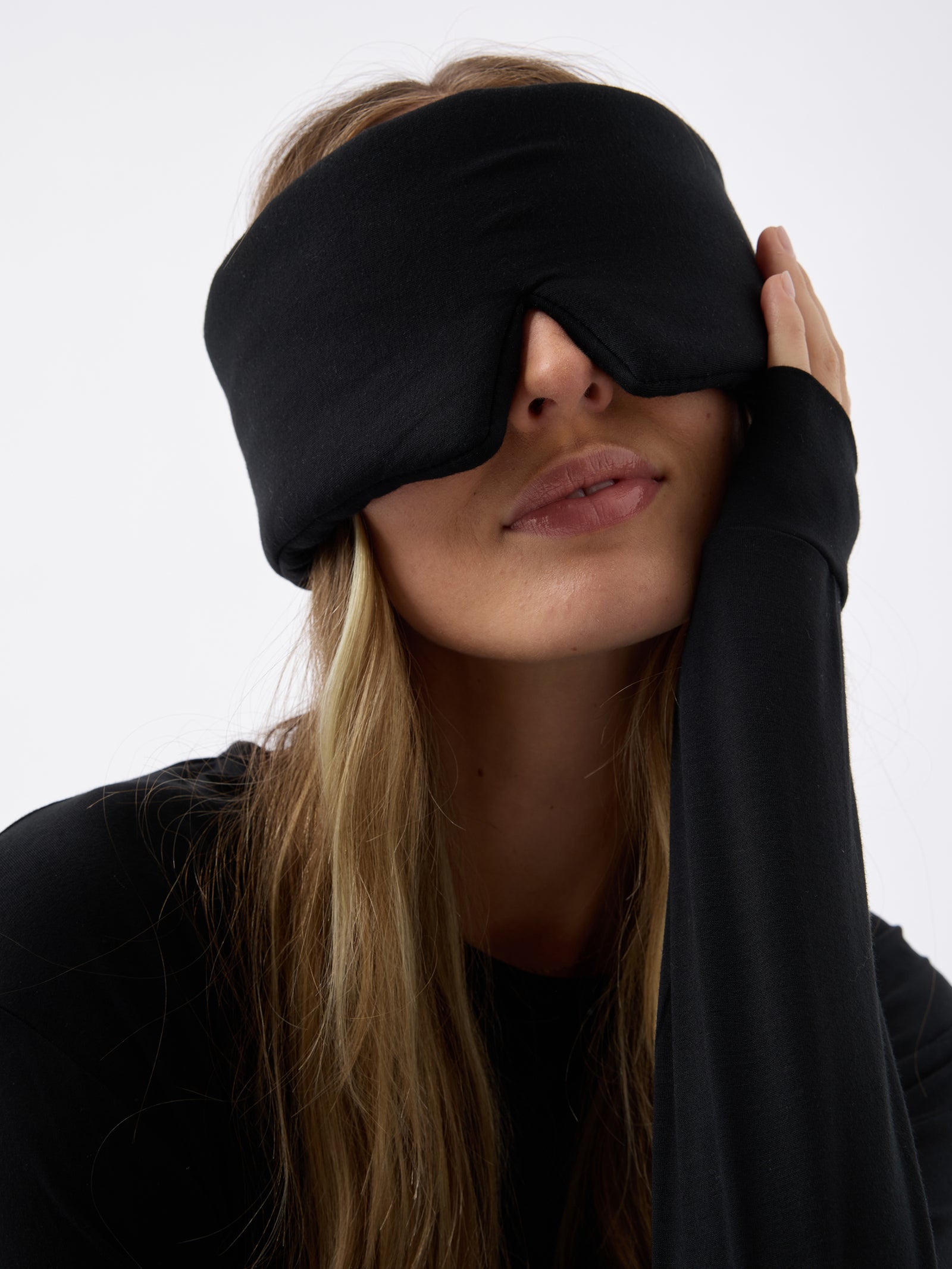 A woman wears the Cozy Earth Adjustable Bamboo Sleep Mask in Black. 