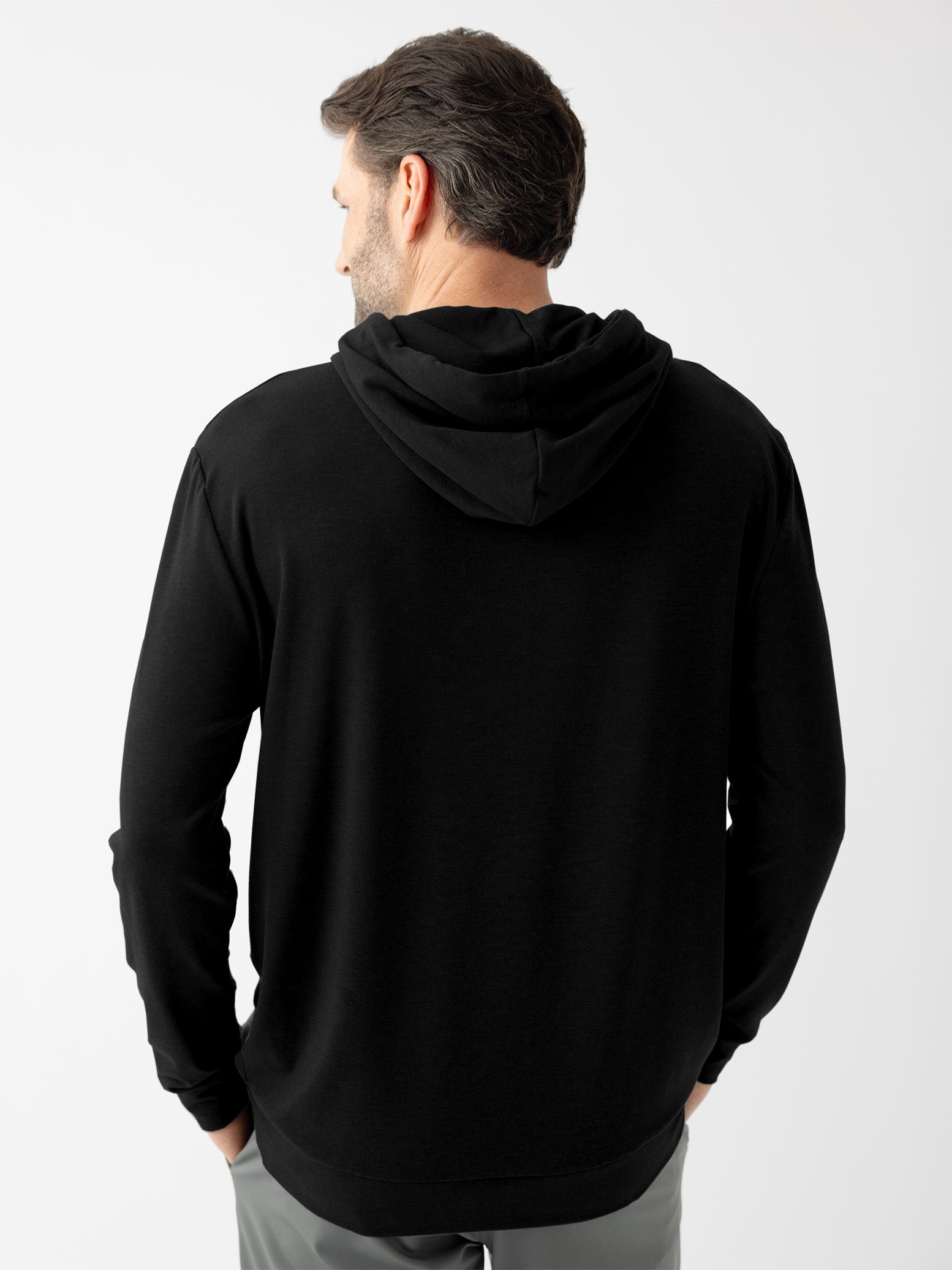 Back of man wearing black hoodie with white background 