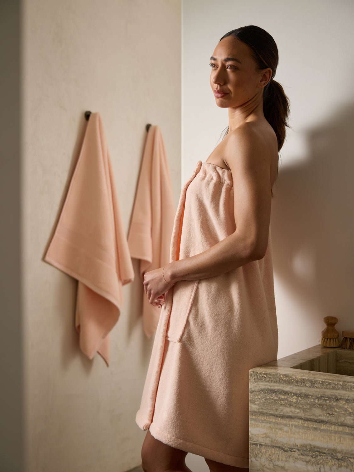 Woman in bathroom wearing pink towel wrap 