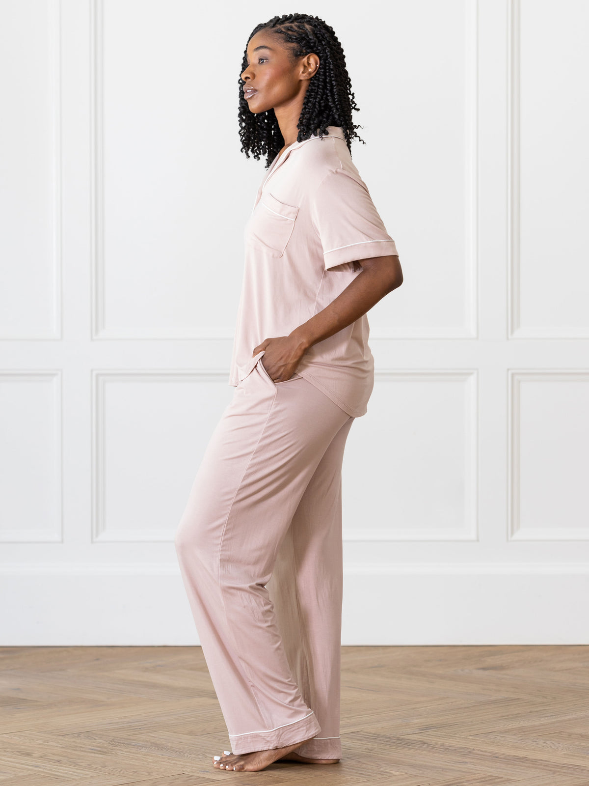 Blush Short Sleeve & Pant Bamboo Pajama Set modeled by a woman. The photo was taken in a high contrast setting, showing off the colors and lines of the pajamas. 