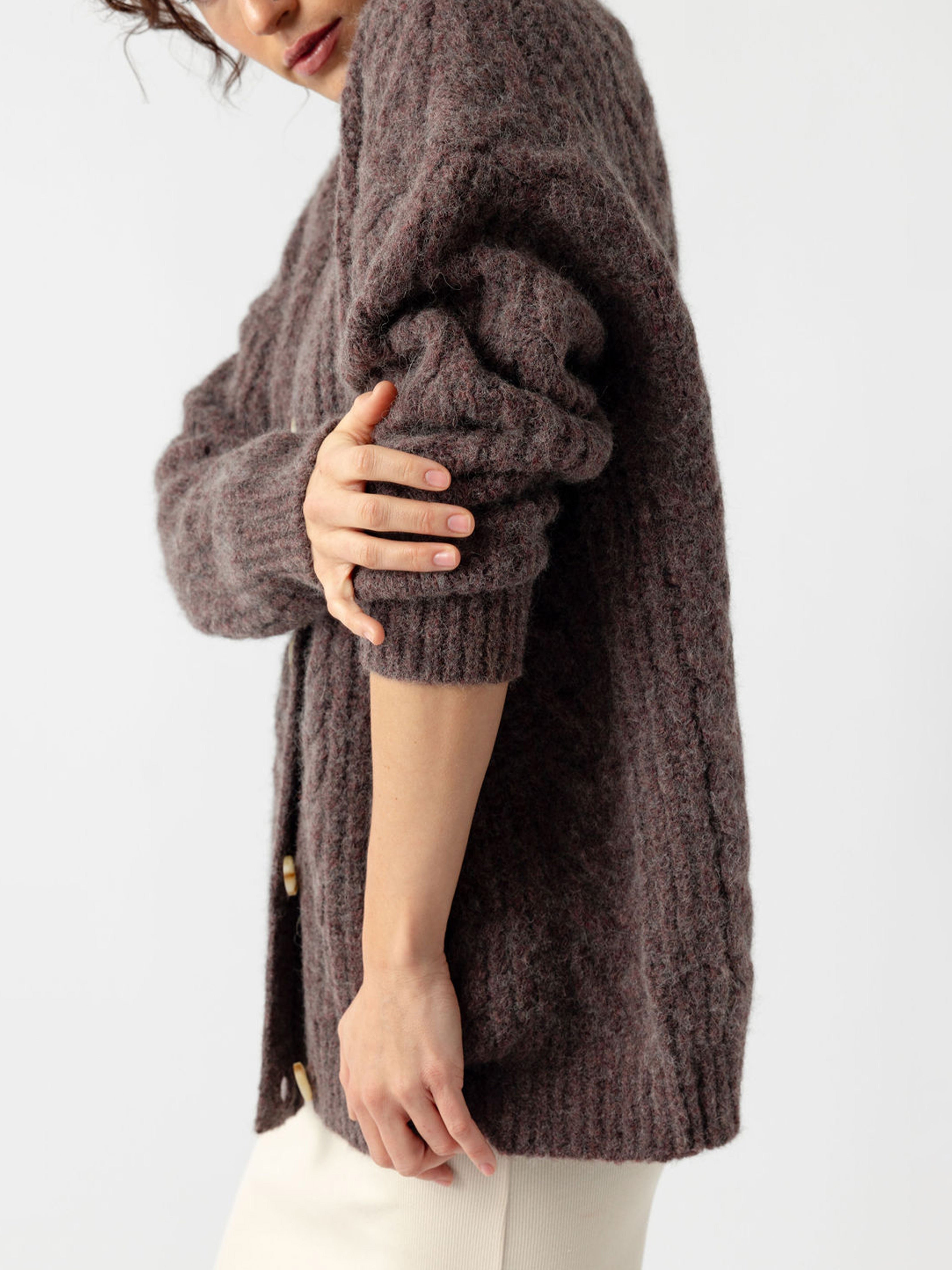 Studio image of woman in bordeaux xardigan wiht sleeve rolled up 