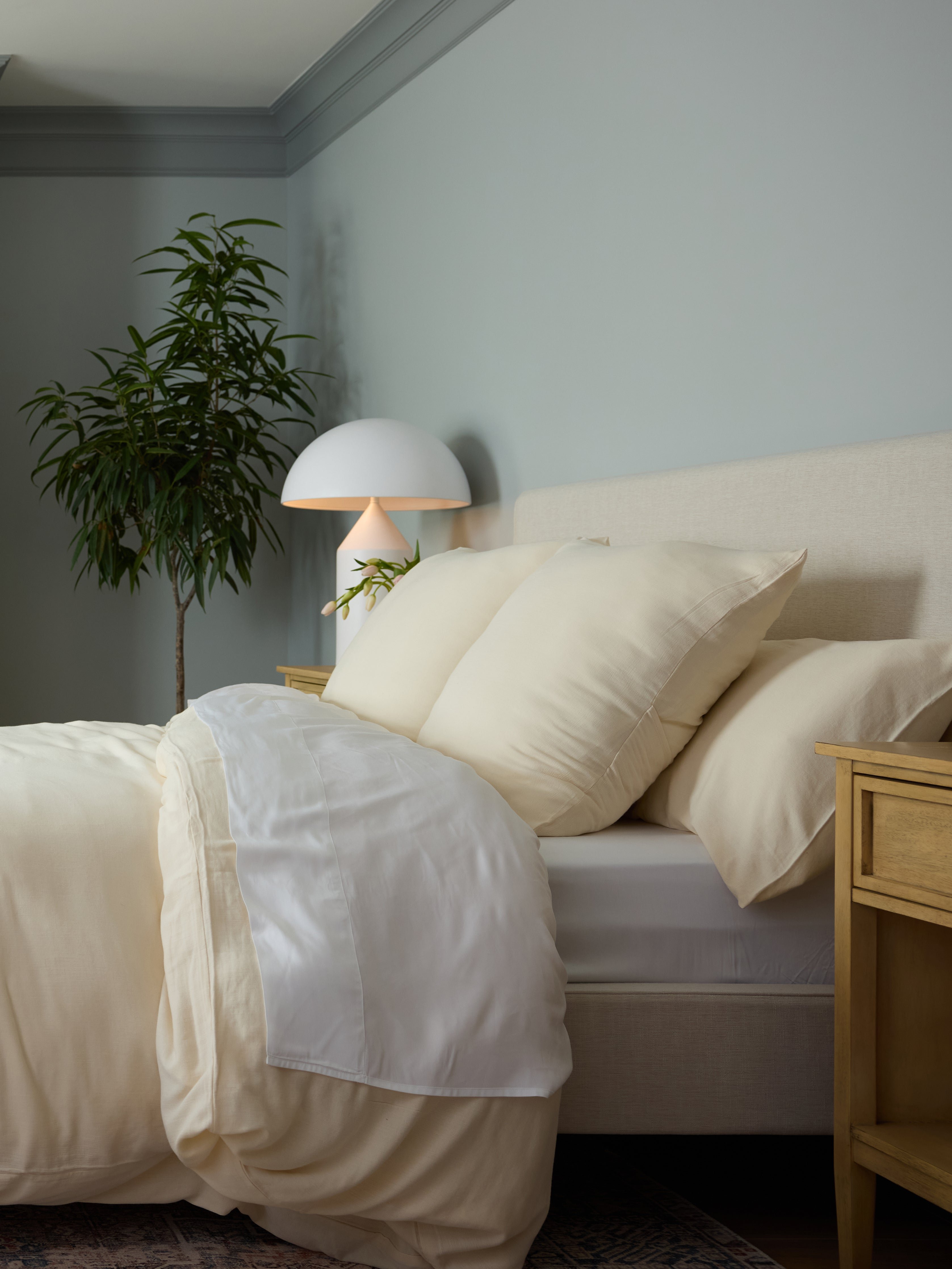 Buttermilk Aire Bamboo Shams. The shams are resting on a bed in a bedroom