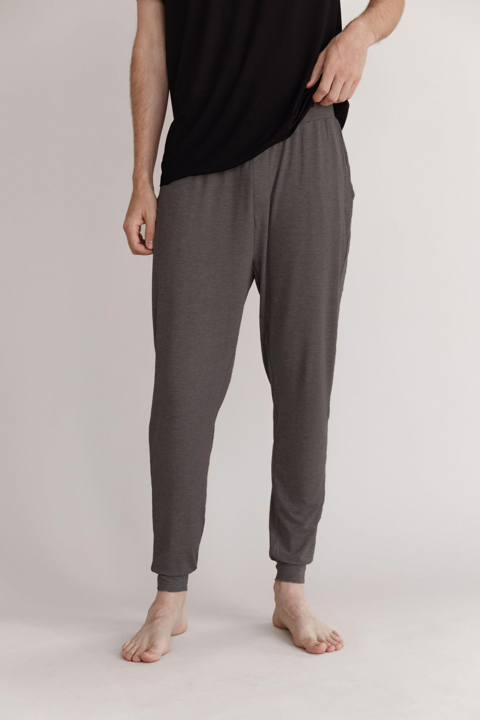 Man in charcoal pajama joggers with white background 