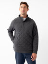 A person stands against a plain white background wearing a Cozy Earth Men's Ultra-Soft Bamboo Quilted Snap Pullover with a high collar and two buttons at the neckline. They have short hair and are looking slightly upward with a relaxed expression. Their hand rests casually in their pocket. |Color:Charcoal
