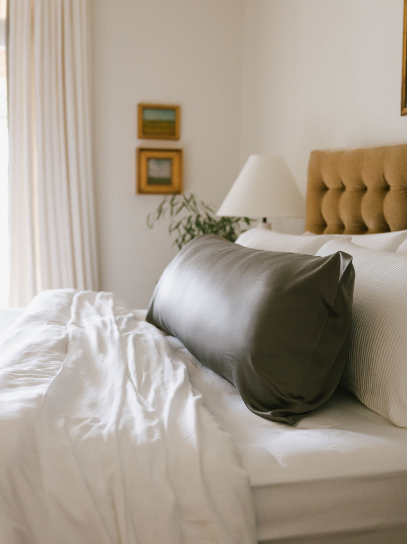 Side view of body pillow with charcoal case on bed